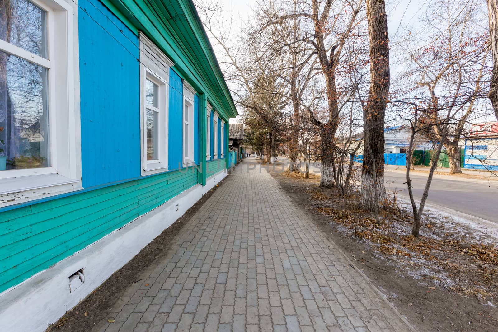 An old one-story wooden house with carved shutters in the Russian style.