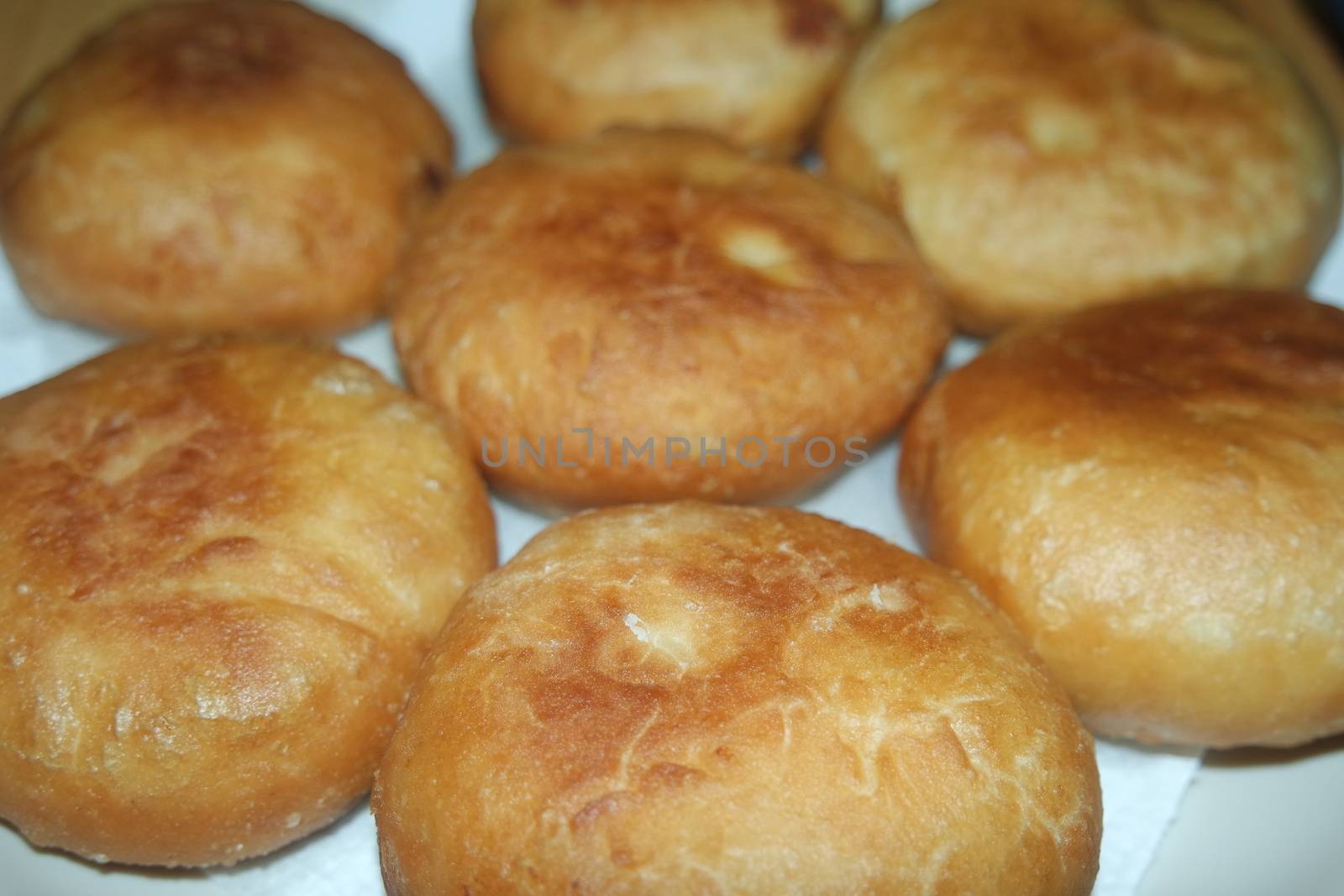 Closeup view of homemade tasty potato bread rolls bun placed over white tissue paper.