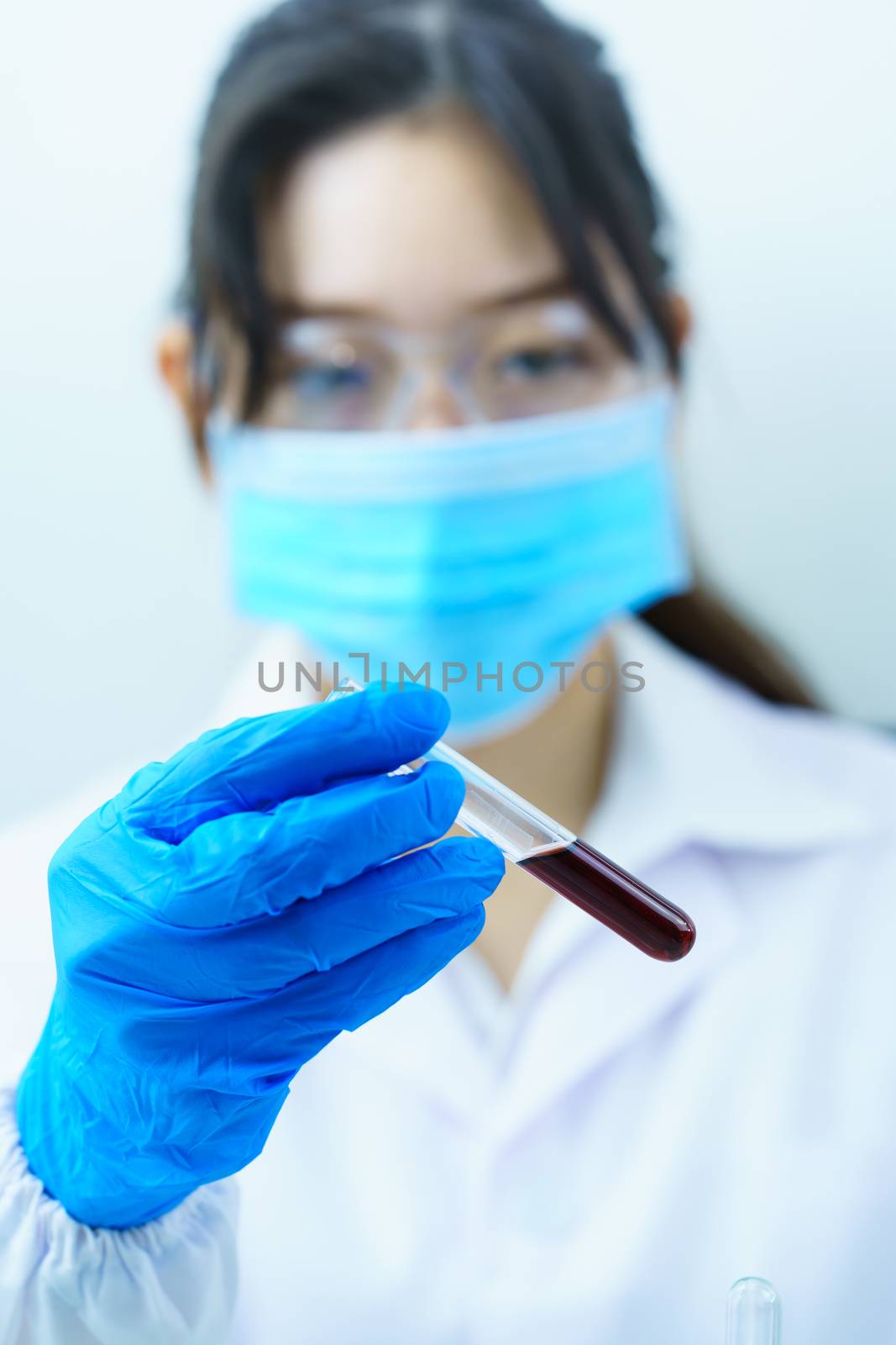 Technician scientist analyzing holding blood sample in test tube in laboratory for testing it on COVID, COVID-19, coronavirus virus analysis