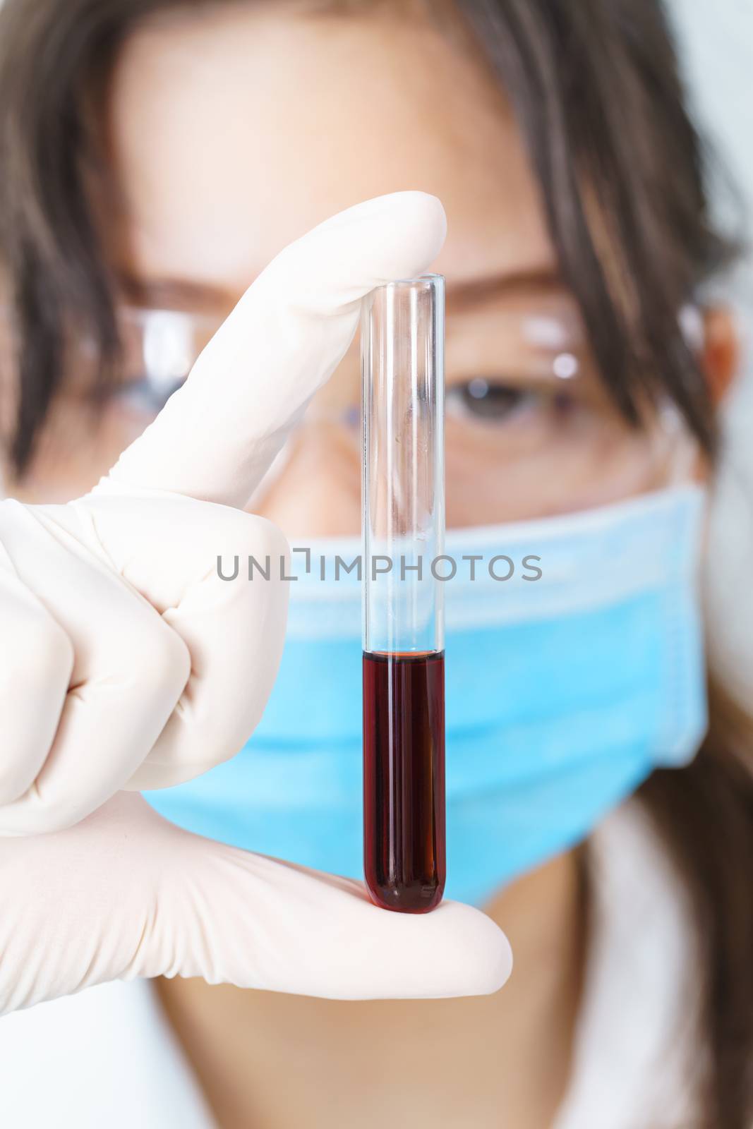 Scientist analyzing holding blood sample in test tube by stoonn
