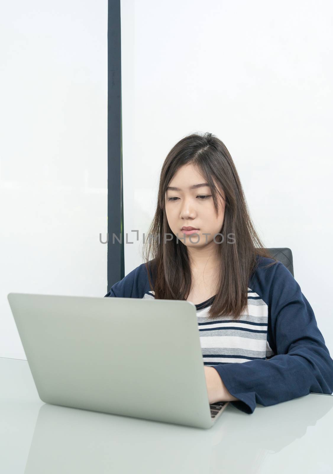 Young female student  sitting in living room and learning online by stoonn