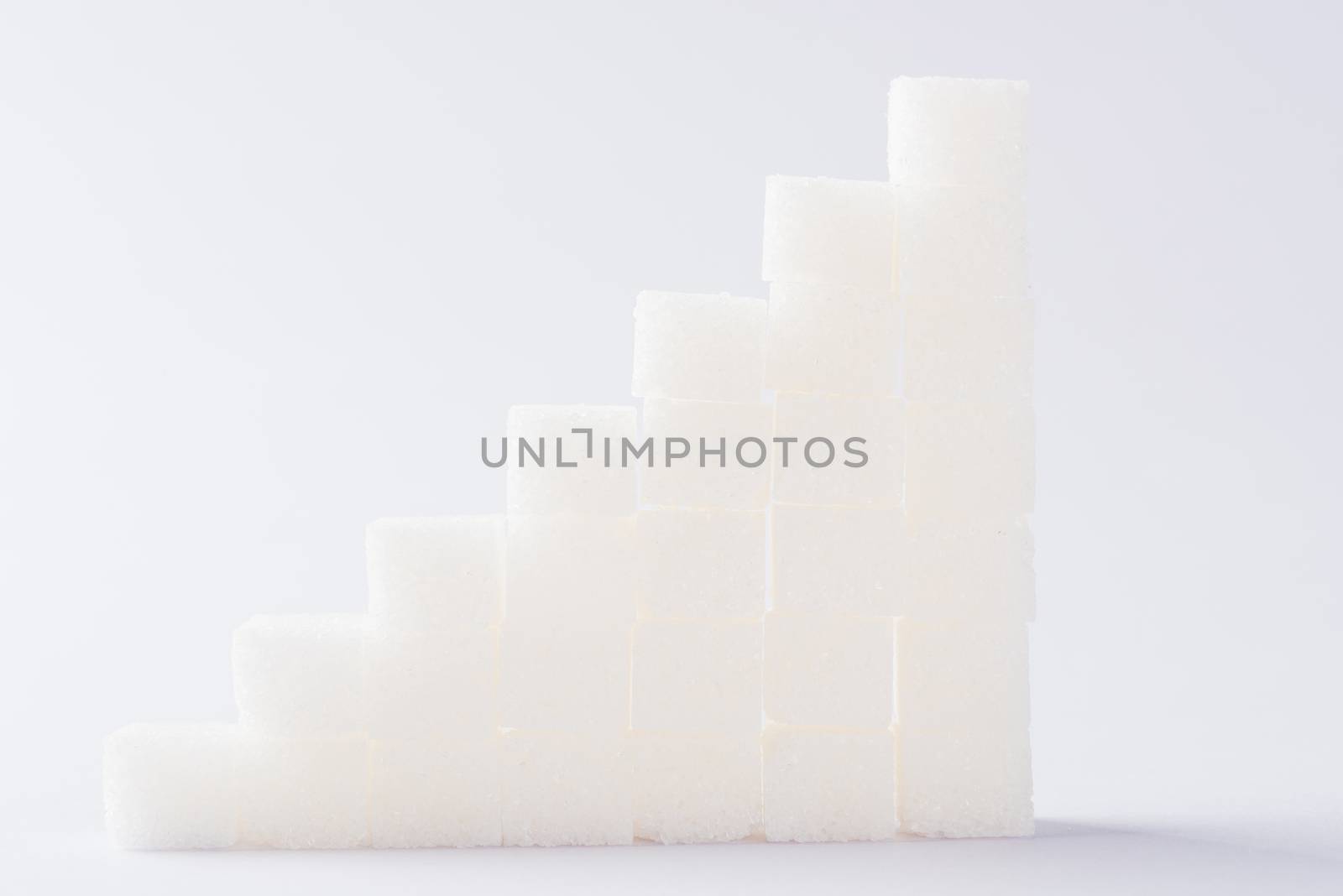 Ascending stacks of sugar cubes graph chart, studio shot isolated on white background, health high blood risk of diabetes concept