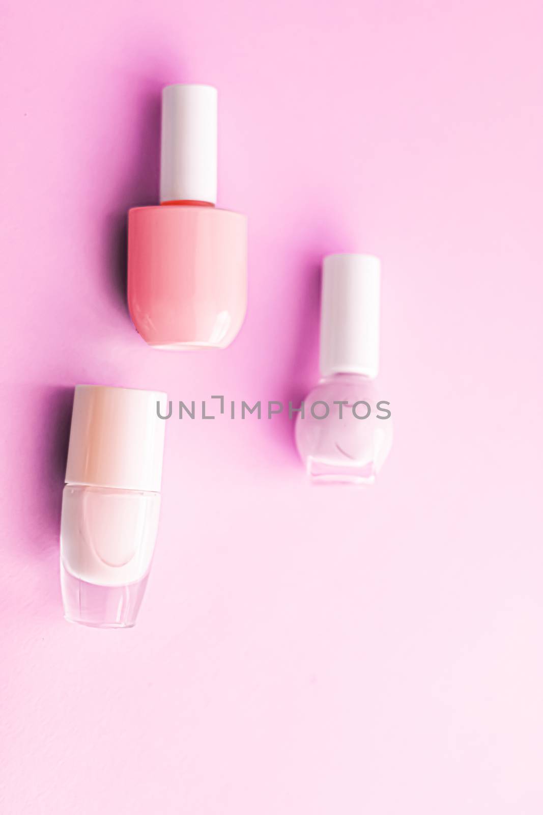 Nail polish bottles on pink background, beauty brand by Anneleven