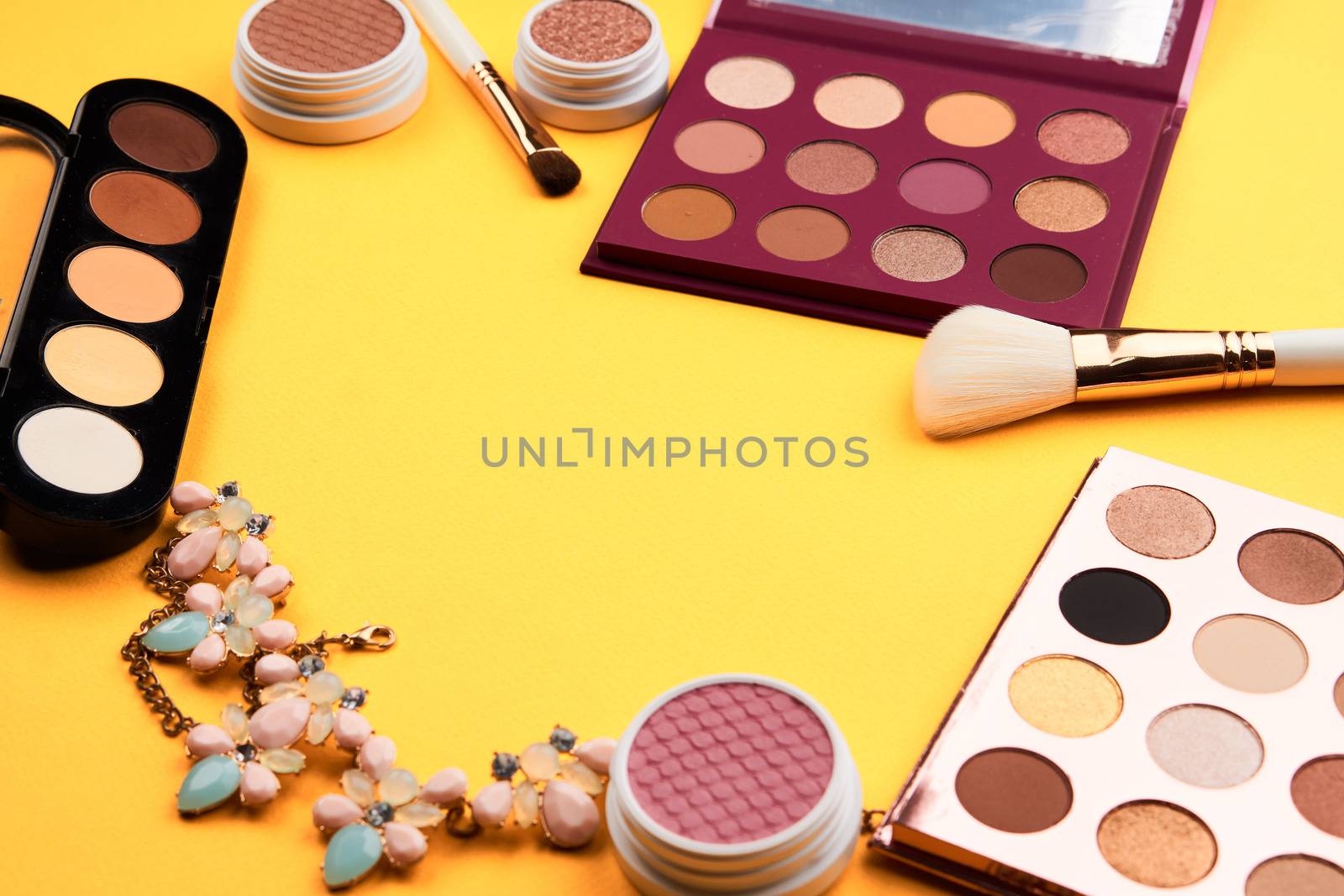 Professional eyeshadows and makeup brushes on a yellow background make-up decoration by SHOTPRIME