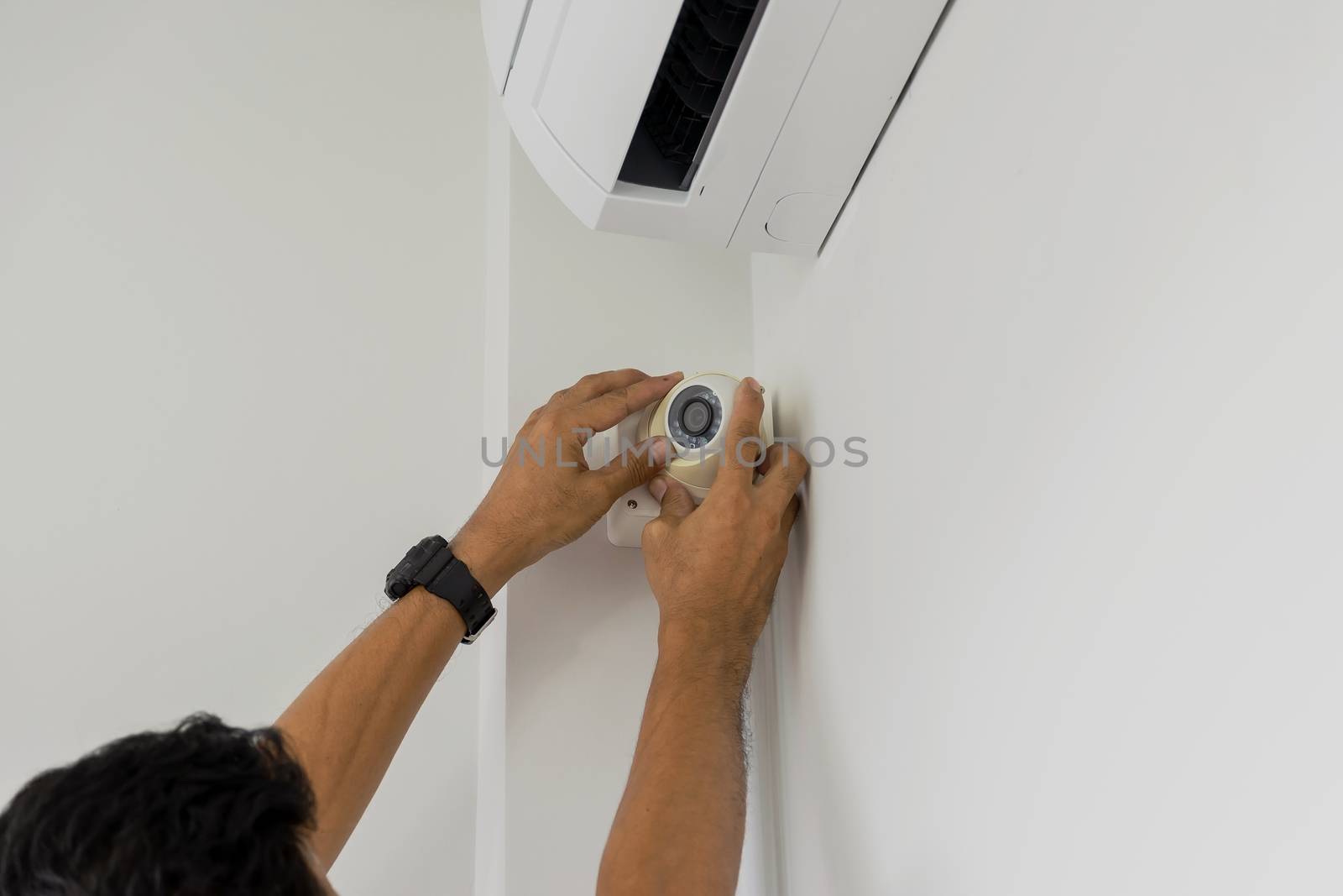 Technicians are installing a cctv camera on the roof, can connect to the Internet, and control the camera via a smartphone or tablet.