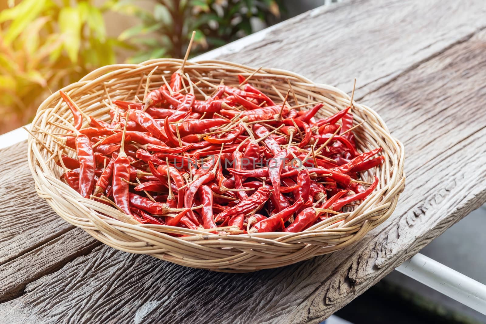 Close-up group of red dried peppers in a wicker basket.