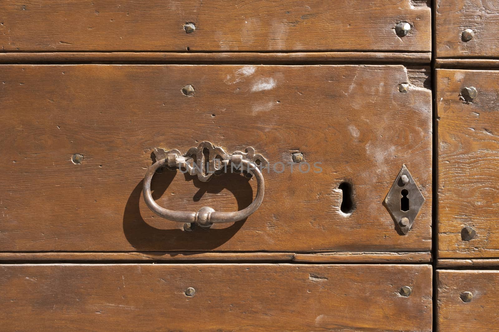 Antique door knocker on wooden door. Vintage, retro background