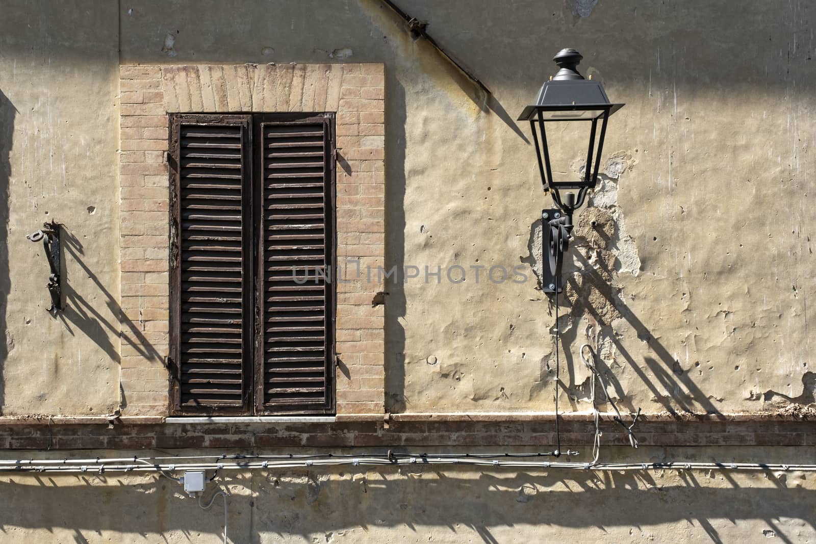 Italian Window with Wooden Shutters in a brick wall. Decorated With Fresh Flowers