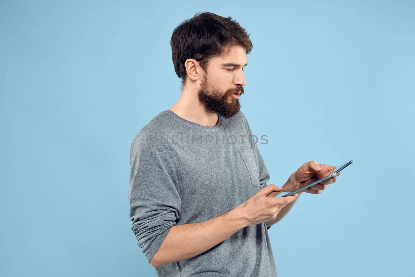 Man with tablet in hands technology lifestyle wireless device blue background. High quality photo