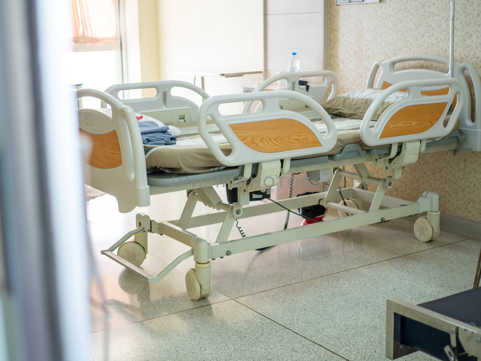 Empty adjustable patient bed in a nursing room For patients admitted to hospital for medical treatment Health insurance concept.