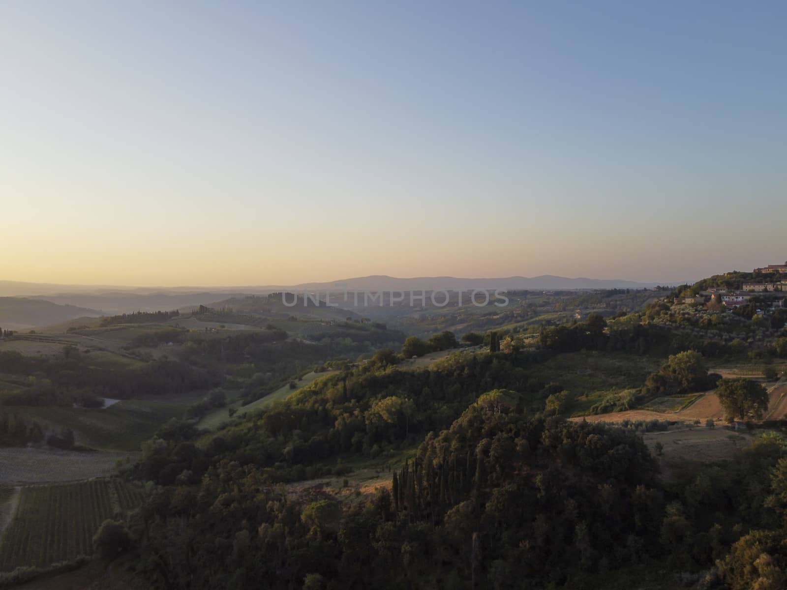Tuscany, rural landscape in Crete Senesi land. Rolling hills, countryside farm, cypresses trees, green field on warm sunset. Siena, Italy, Europe