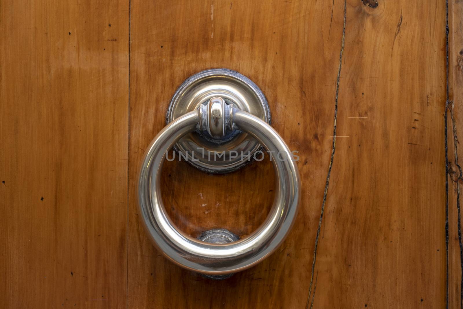 Vintage ornamented image of ancient door knocker on a wooden door.