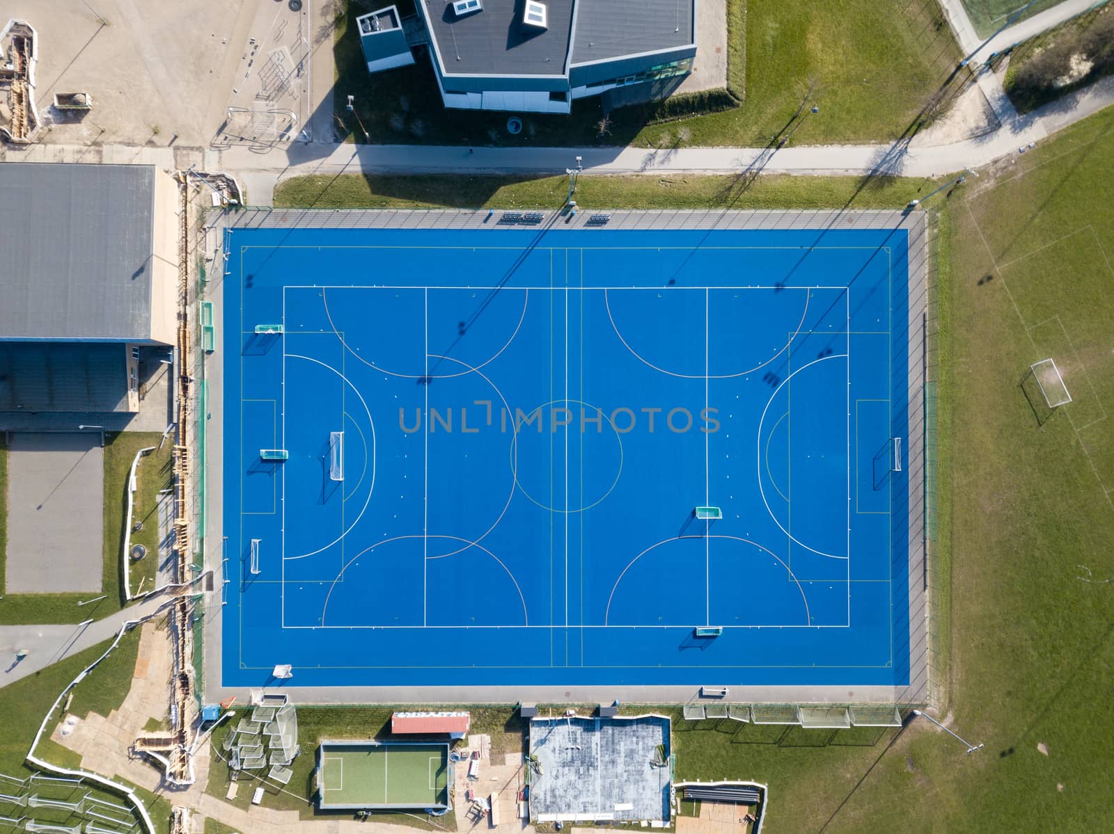 Valby, Denmark - March 22, 2020: Top down aerial drone view of a blue soccer field.