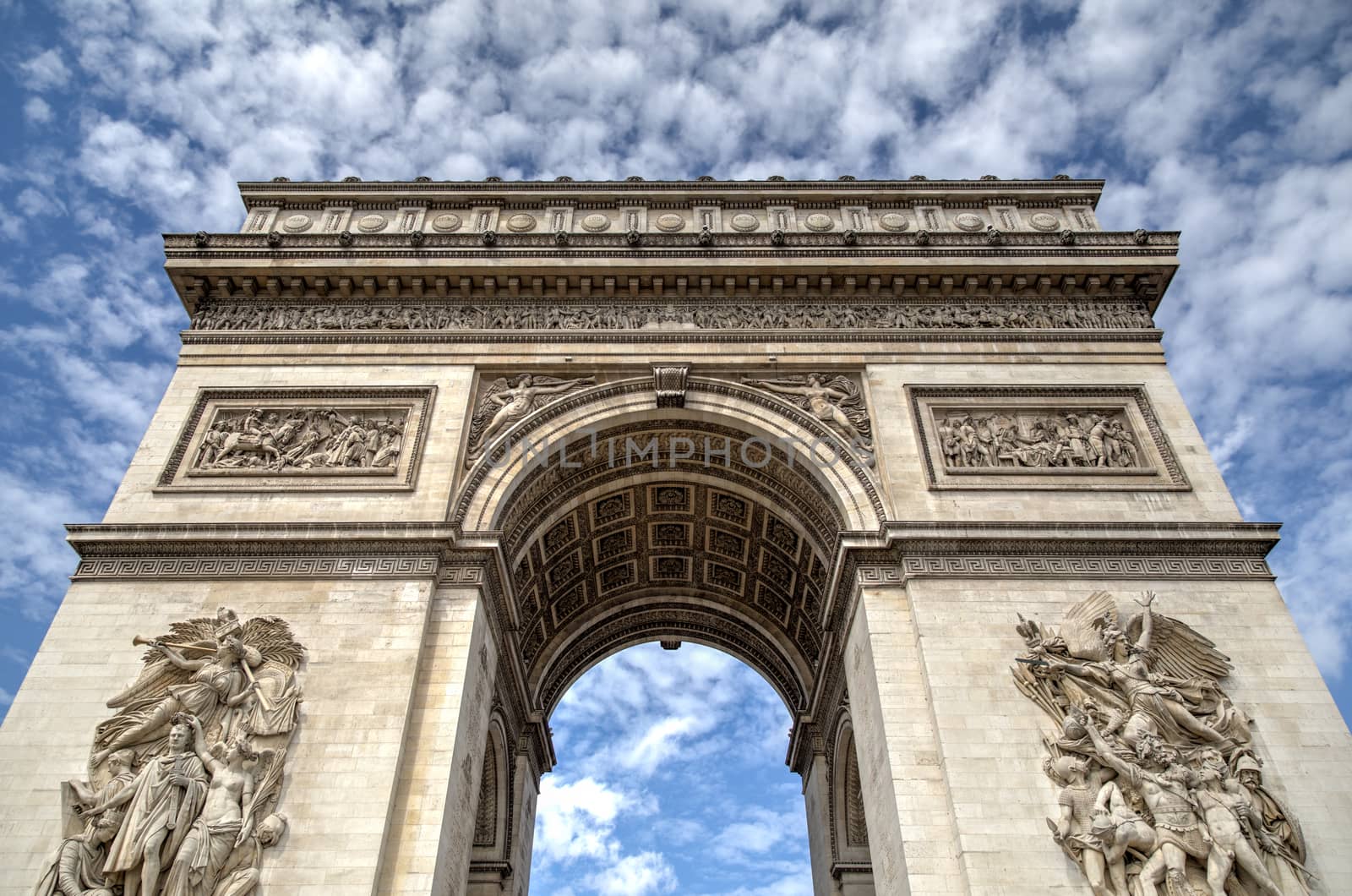 The Arc de Triomphe in Paris against a blue sky