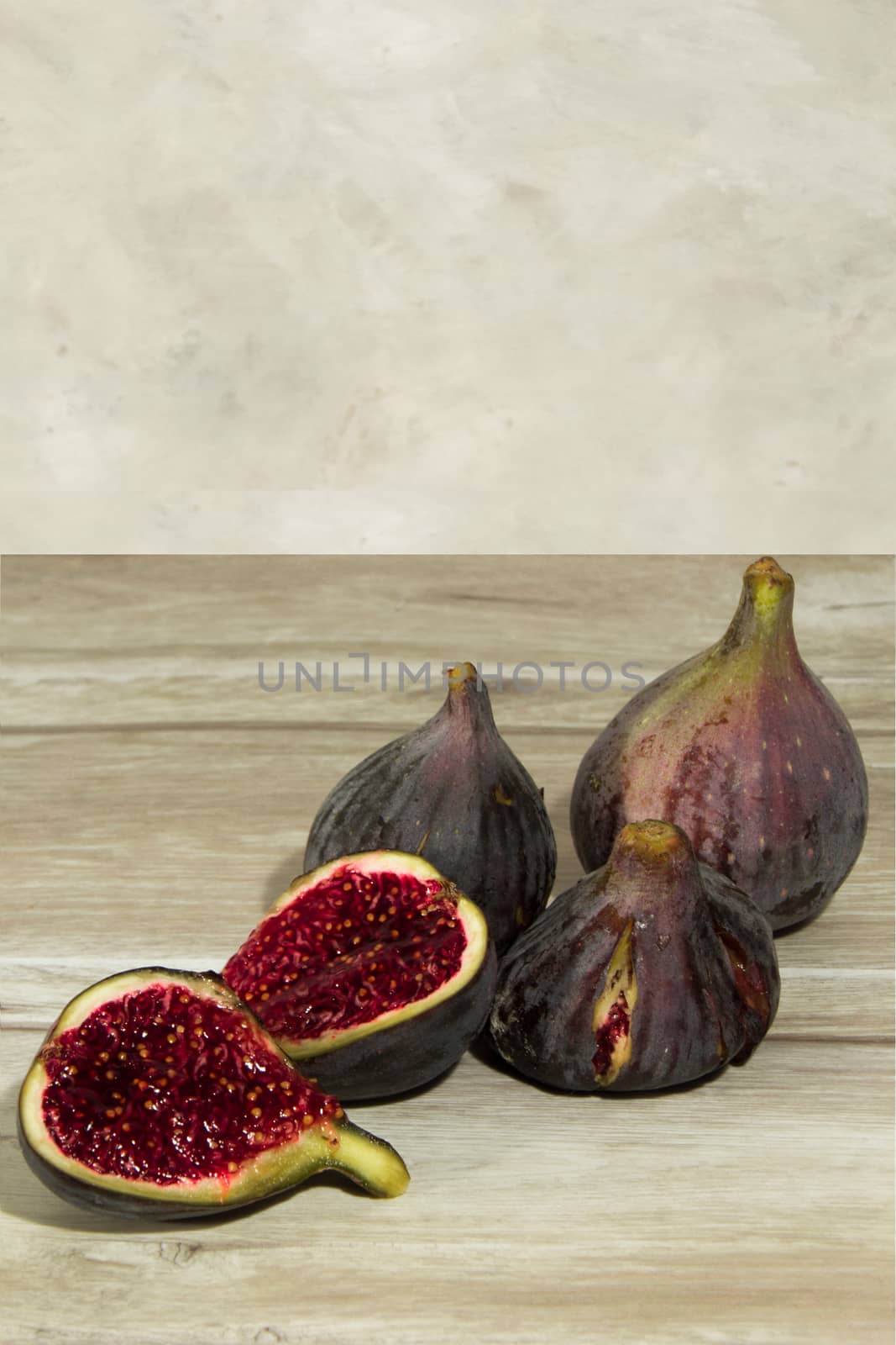 some mature purple figs on the table by Joanastockfoto