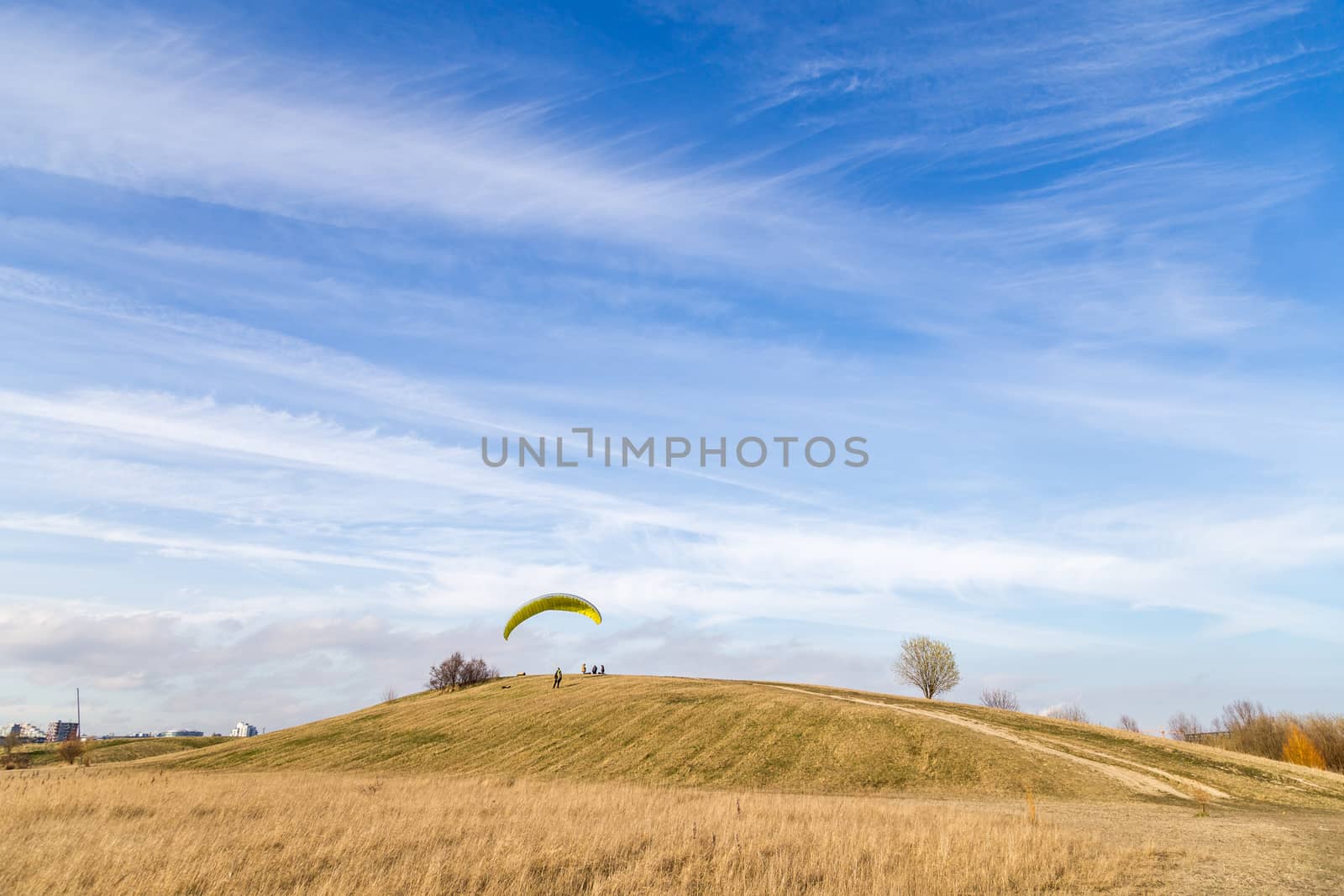 Copenhagen, Denmark - March 28, 2017:  A paraglider trying to start from a small hill just outside the city