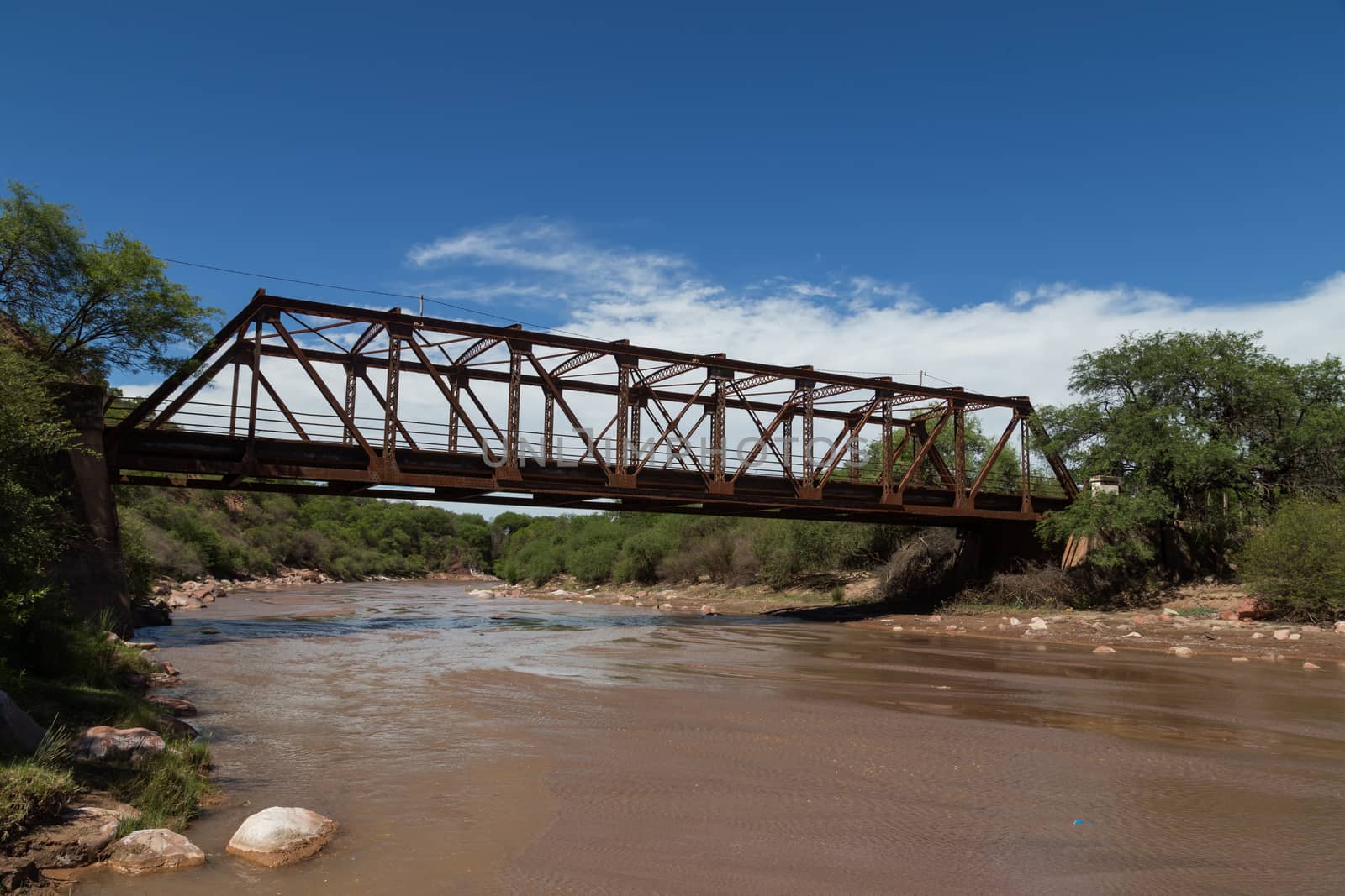 Photograph of a steel bridge construction over a river in the small village Alemania, Argentina.