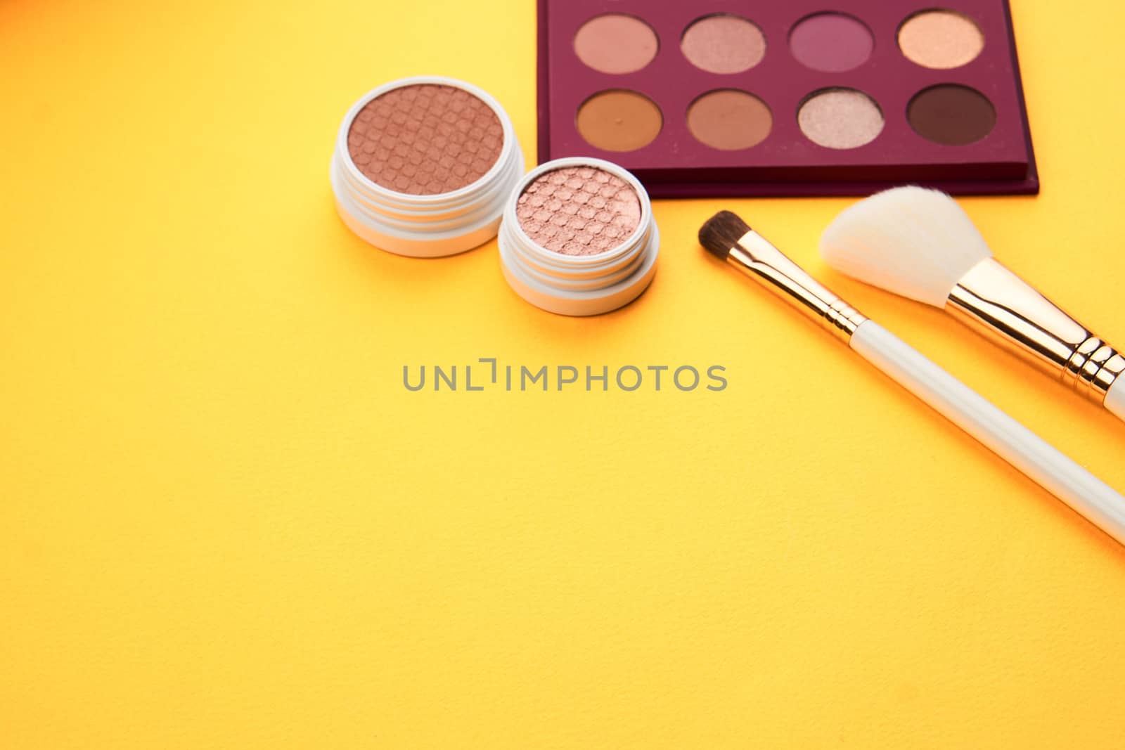 Eyeshadow eye makeup brush on yellow background top view Copy Space by SHOTPRIME