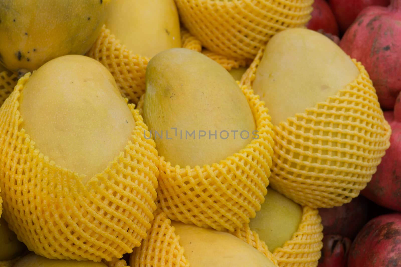 Delicious fresh ripe yellow mango individually wrapped on the market