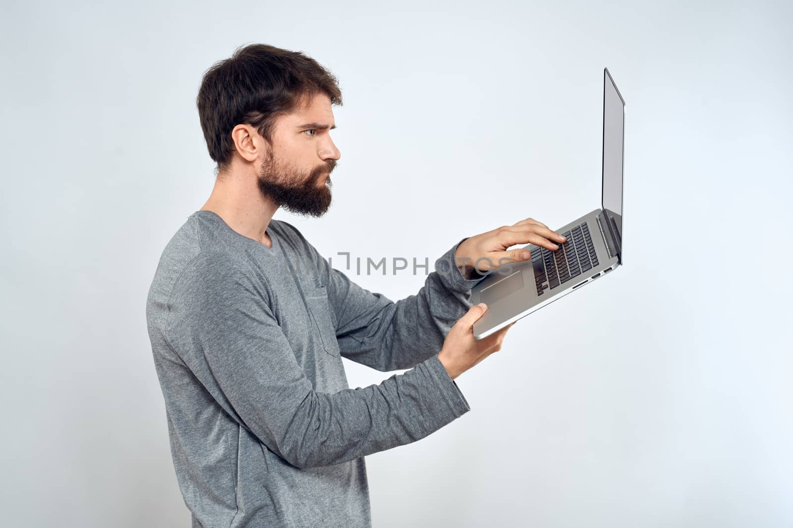 Bearded man with laptop in hands internet communication technology light background by SHOTPRIME