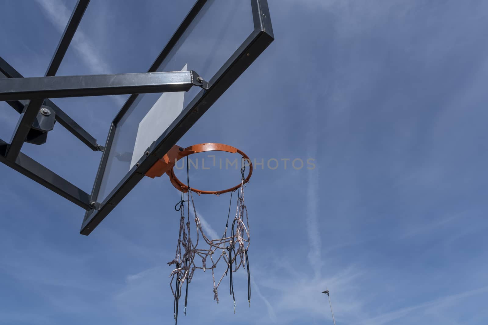 basketball hoop with a red ring against a cloudless warm summer sky by Tjeerdkruse