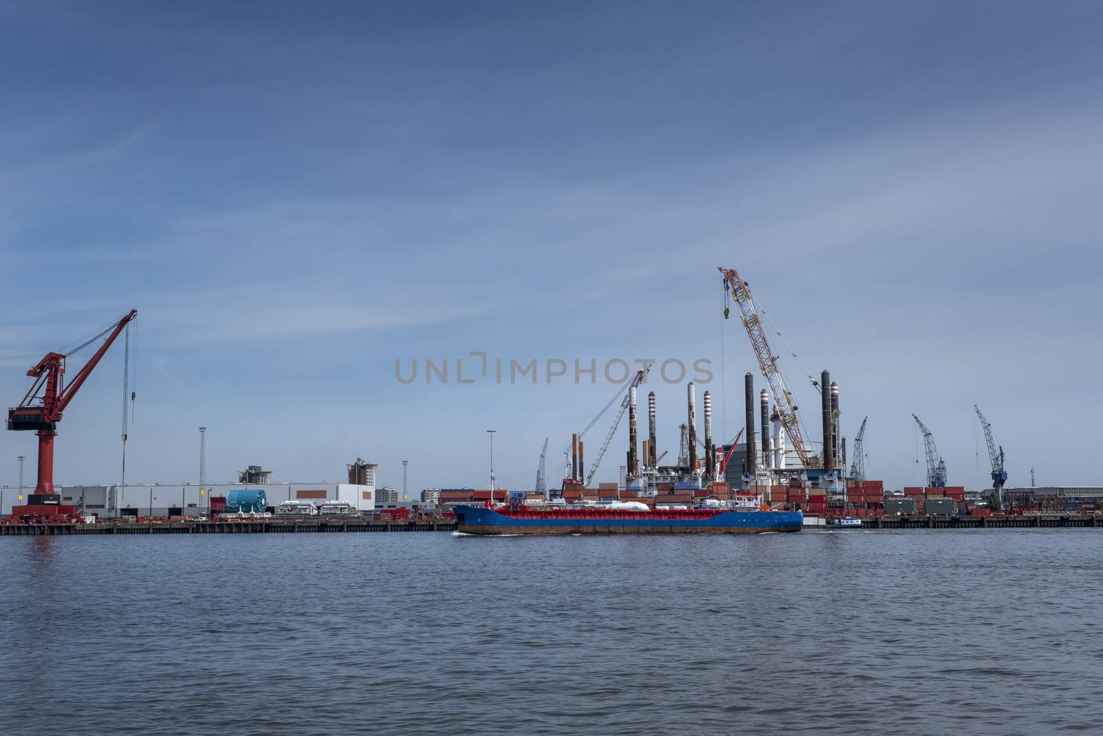 Huge cranes and ships anchored at harbor. International commercial port by Tjeerdkruse