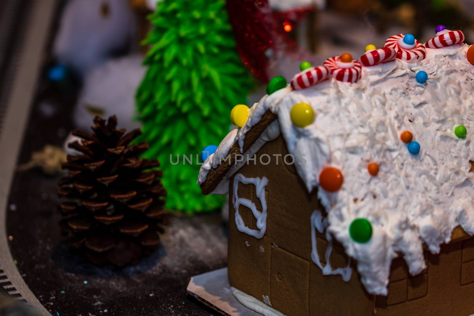 Colorful gingerbread house isolated on blurred background with Christmas decoration.