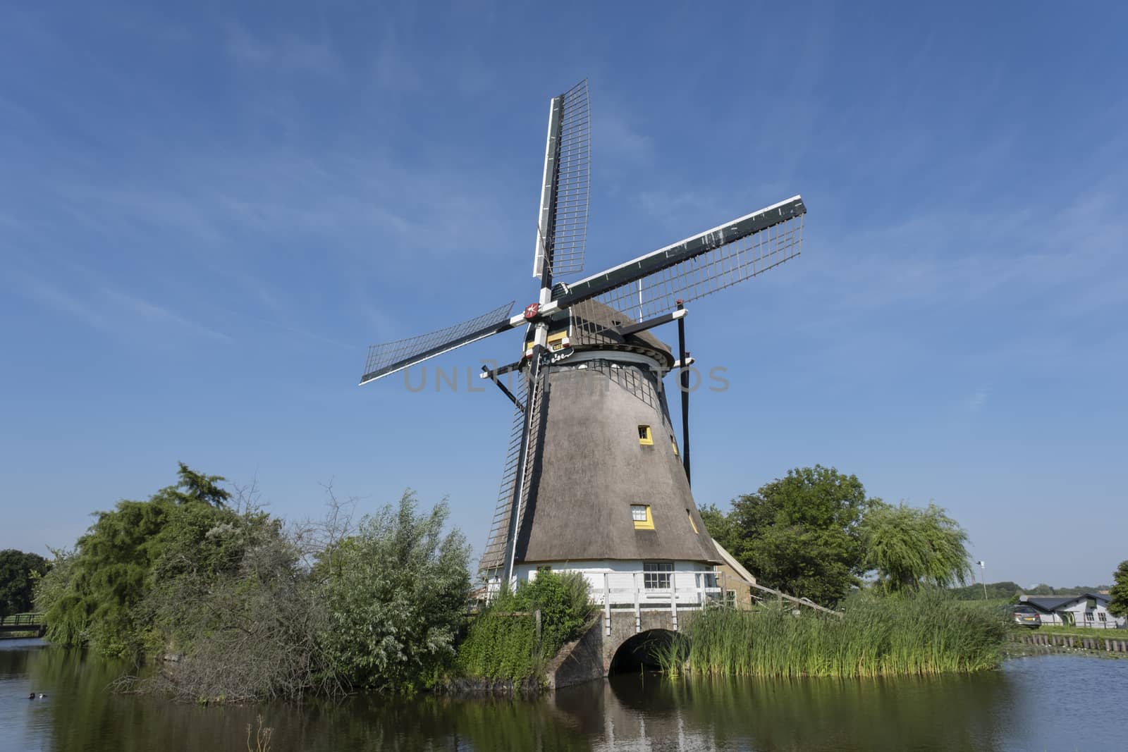 Traditional dutch windmill near the canal. Netherlands. by Tjeerdkruse