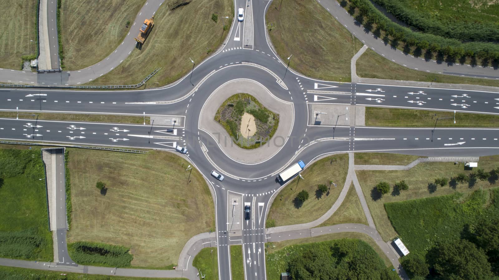 Aerial top down view of a traffic roundabout on a main road in an urban area by Tjeerdkruse