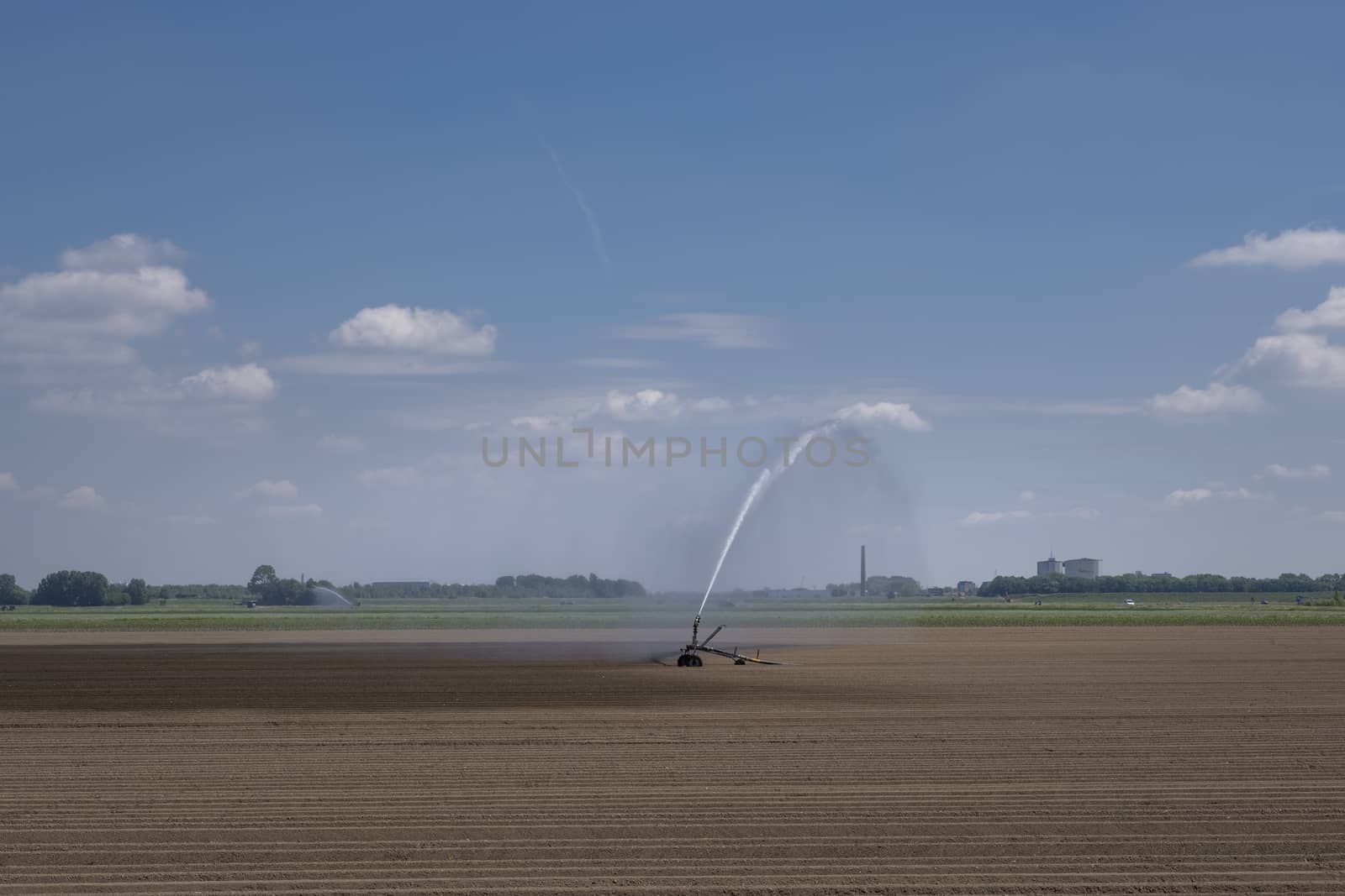 Watering system in a field. An irrigation pivot watering a field