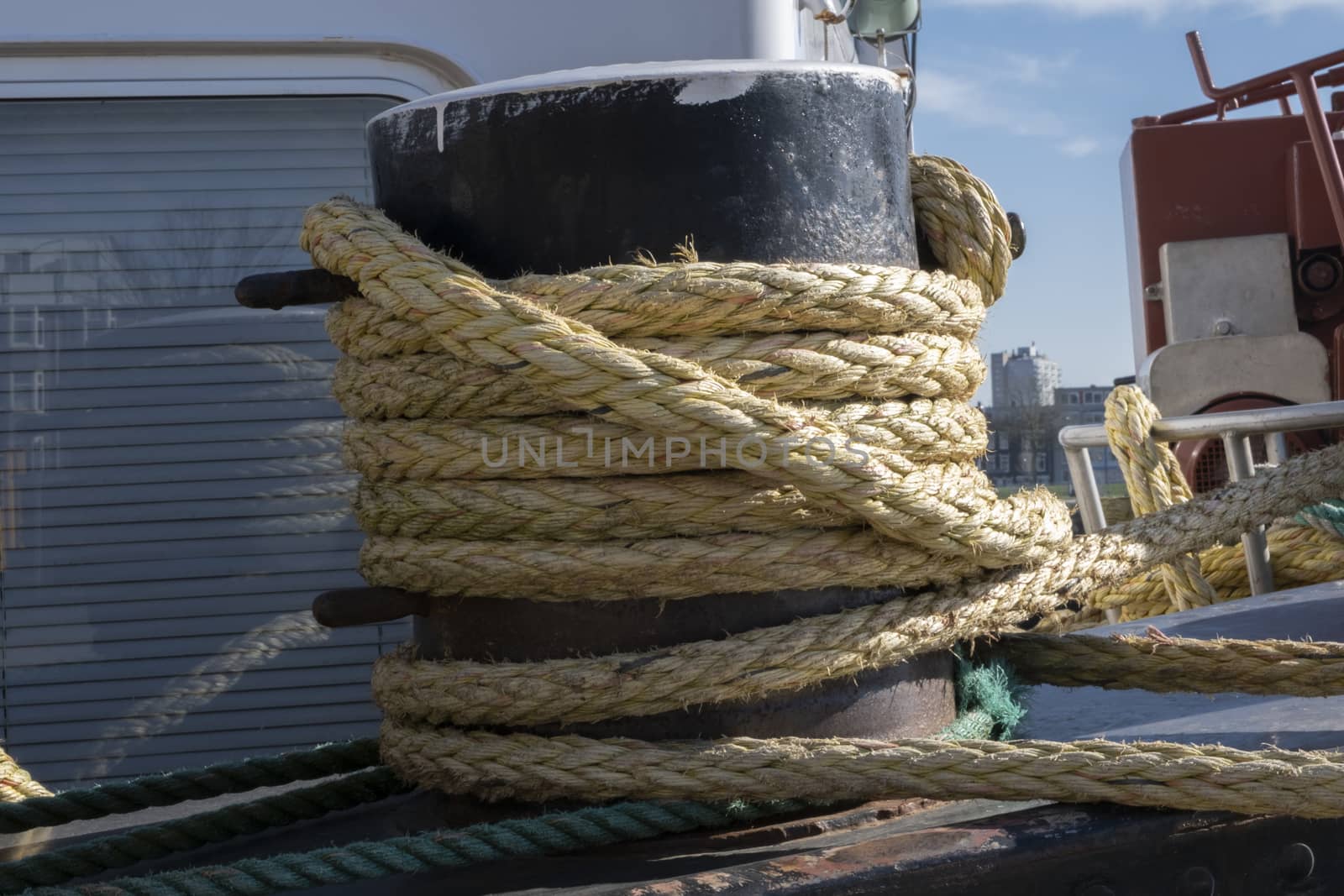A mooring bollard entwined with a mooring rope at port