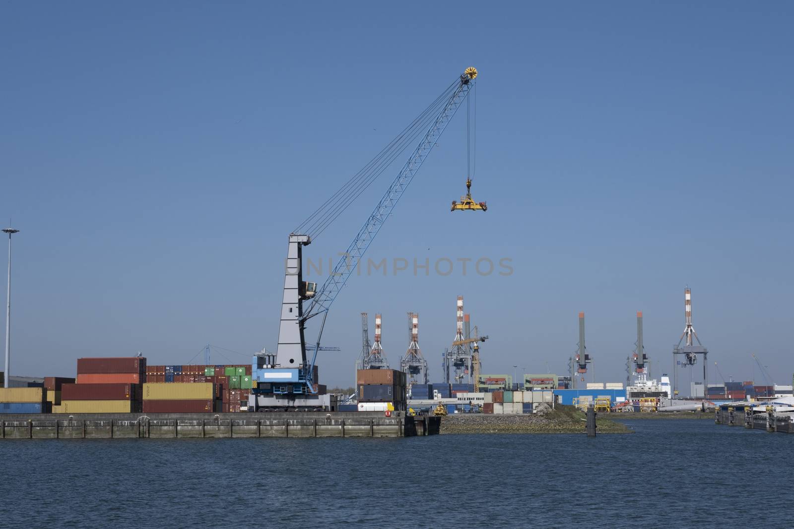 Huge cranes and ships anchored at harbor. International commerci by Tjeerdkruse