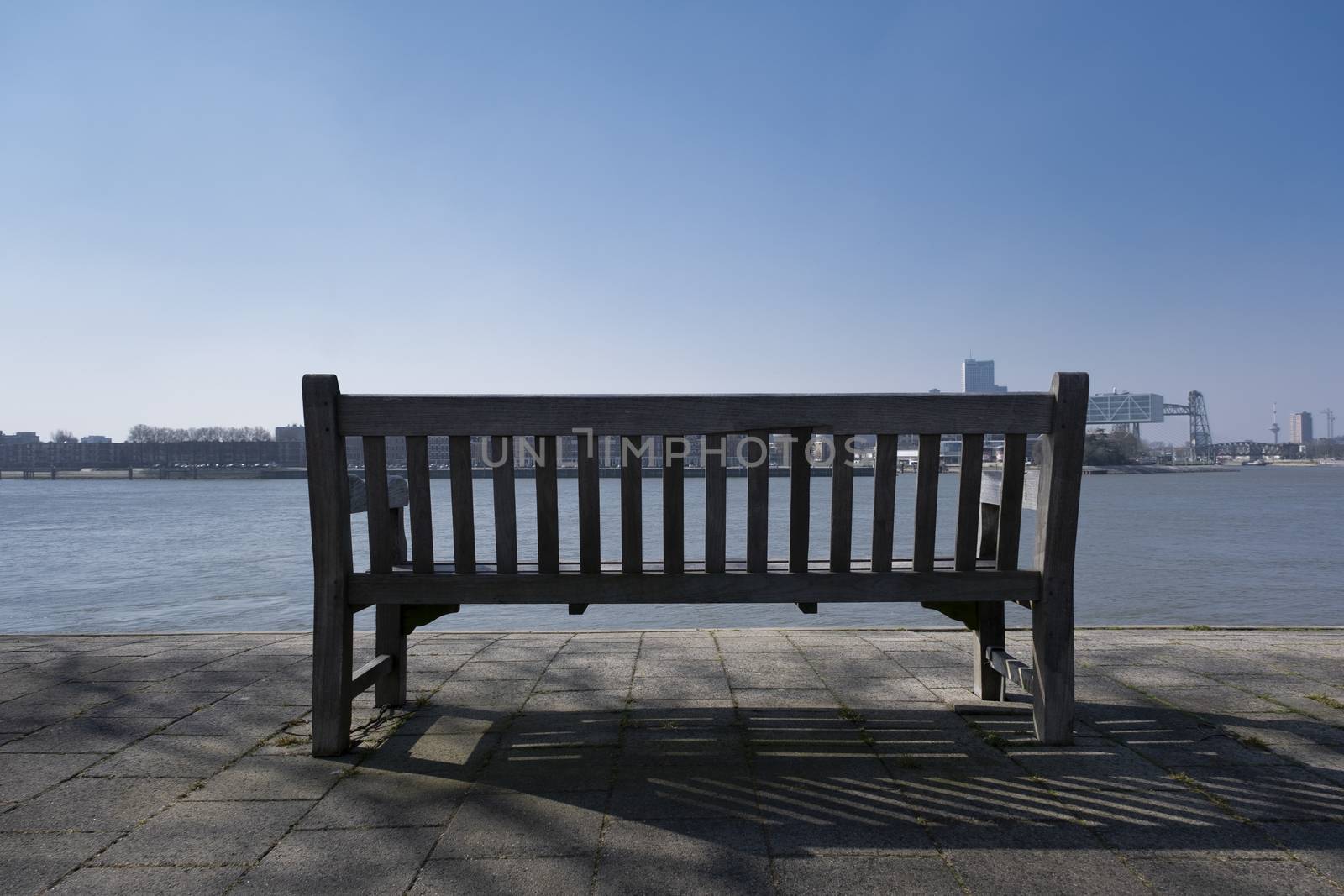 Bench seat in the city of rotterdam with river view by Tjeerdkruse