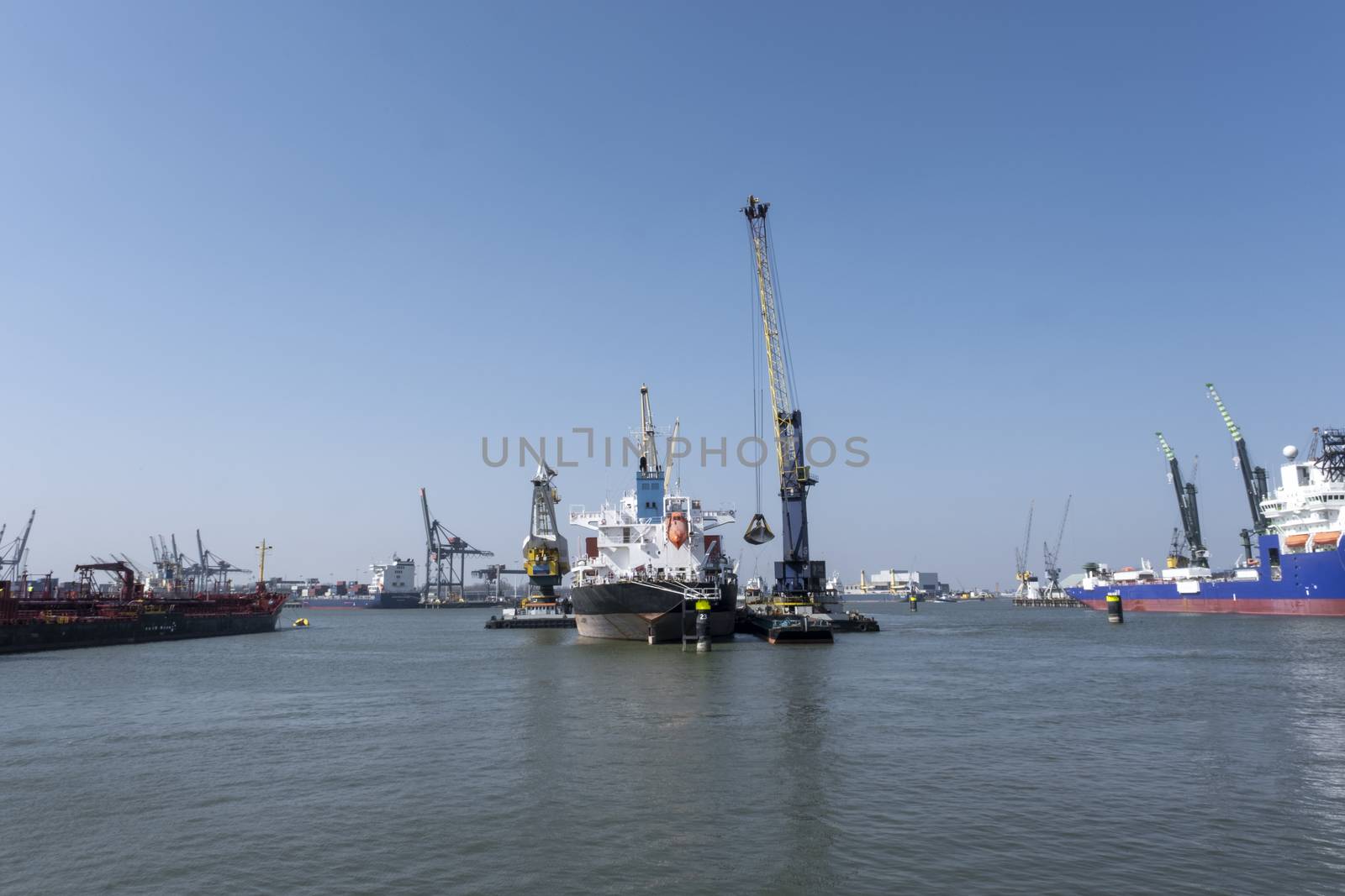 Huge cranes and ships anchored at harbor. International commerci by Tjeerdkruse