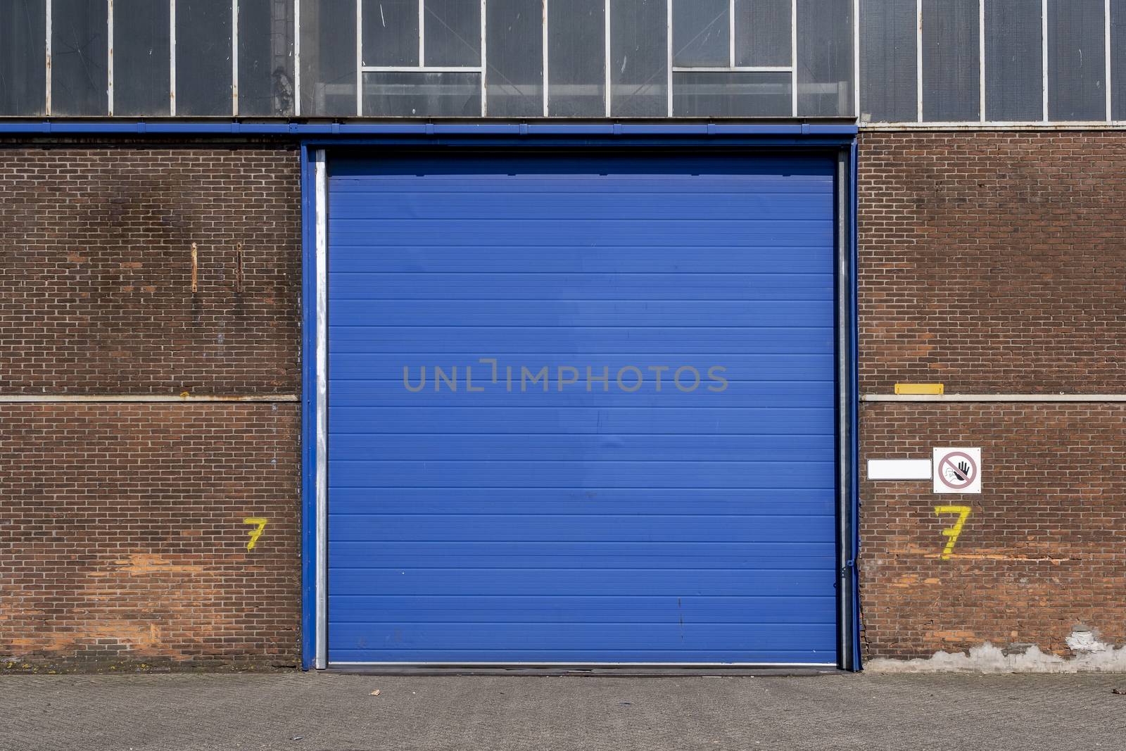 Roller shutter door and concrete floor outside factory building for industrial background.