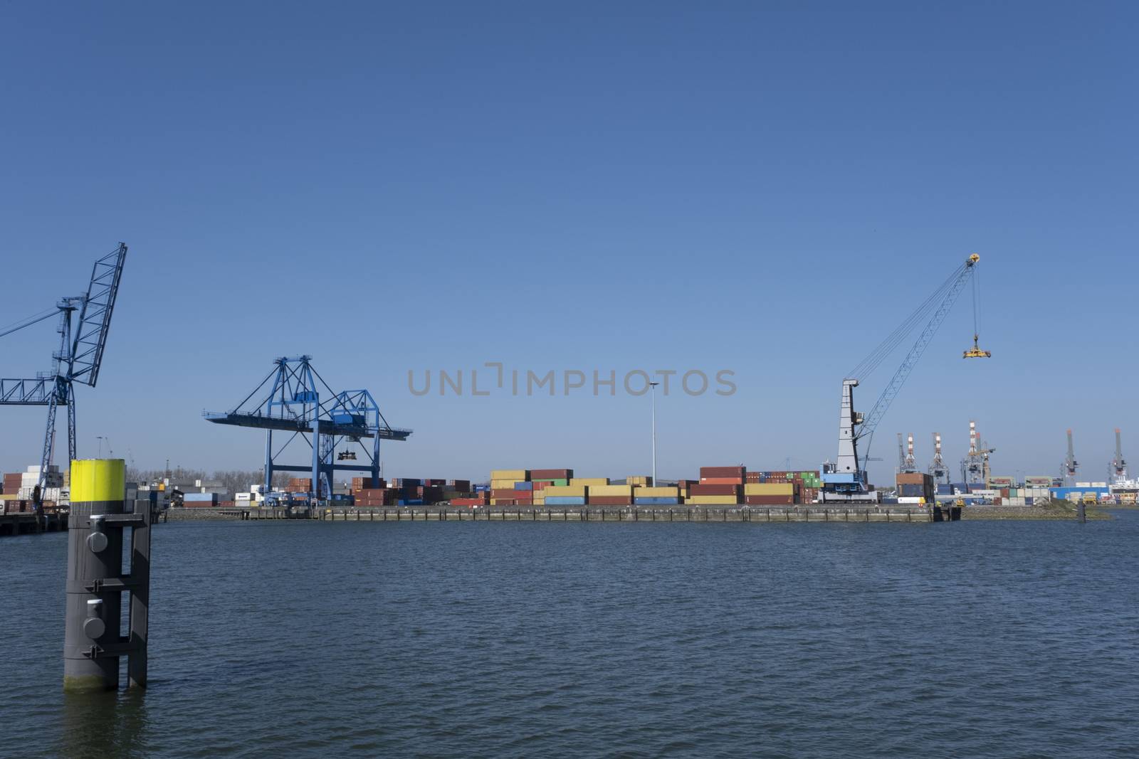 Huge cranes and ships anchored at harbor. International commerci by Tjeerdkruse