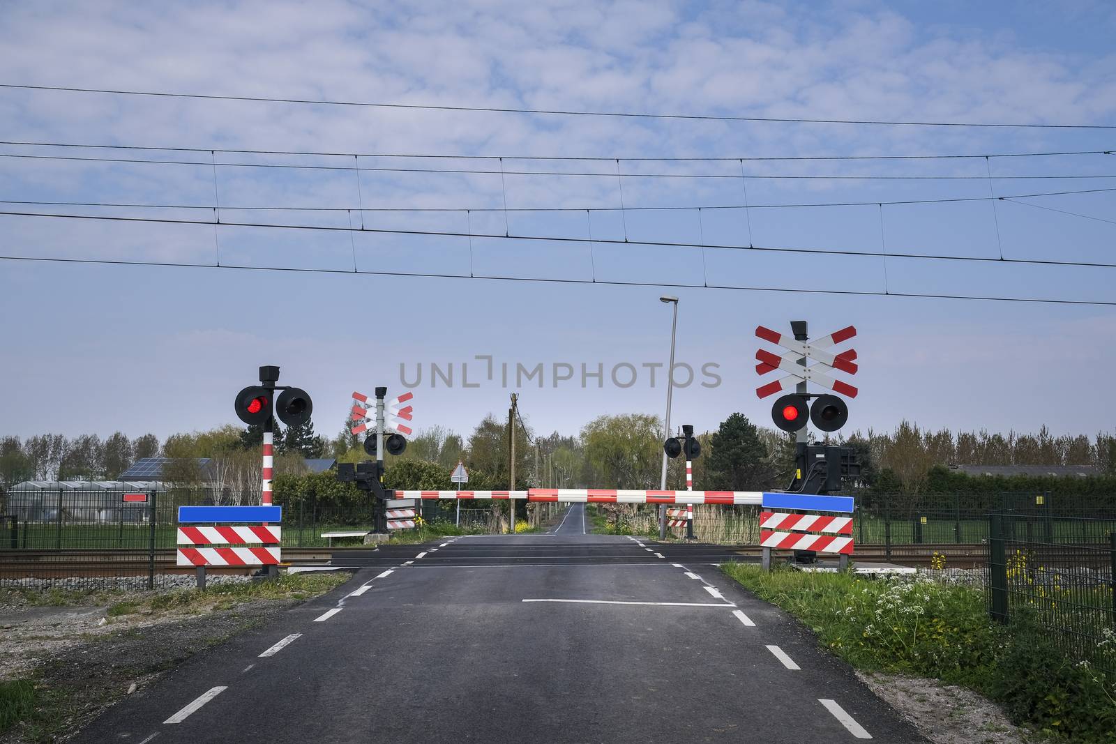 Road signs at the railway crossing with a barrier. Organization  by Tjeerdkruse