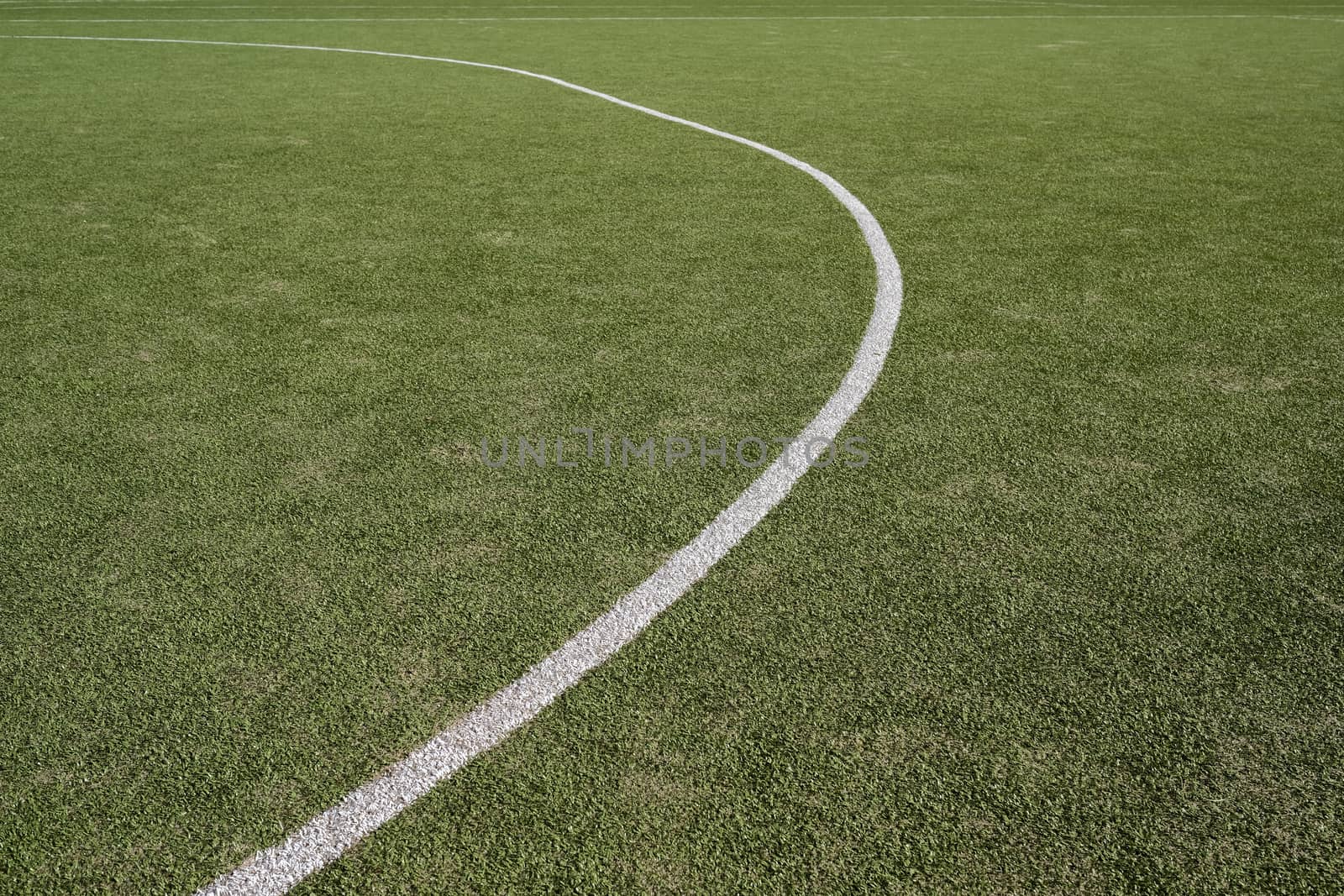 White stripe on a bright green artificial grass soccer field by Tjeerdkruse