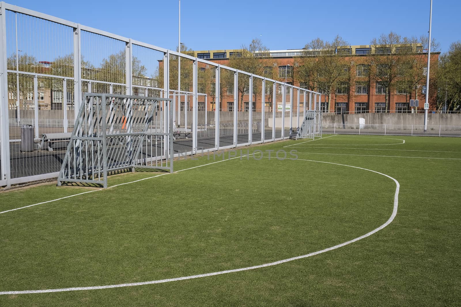 White stripe on a bright green artificial grass soccer field by Tjeerdkruse