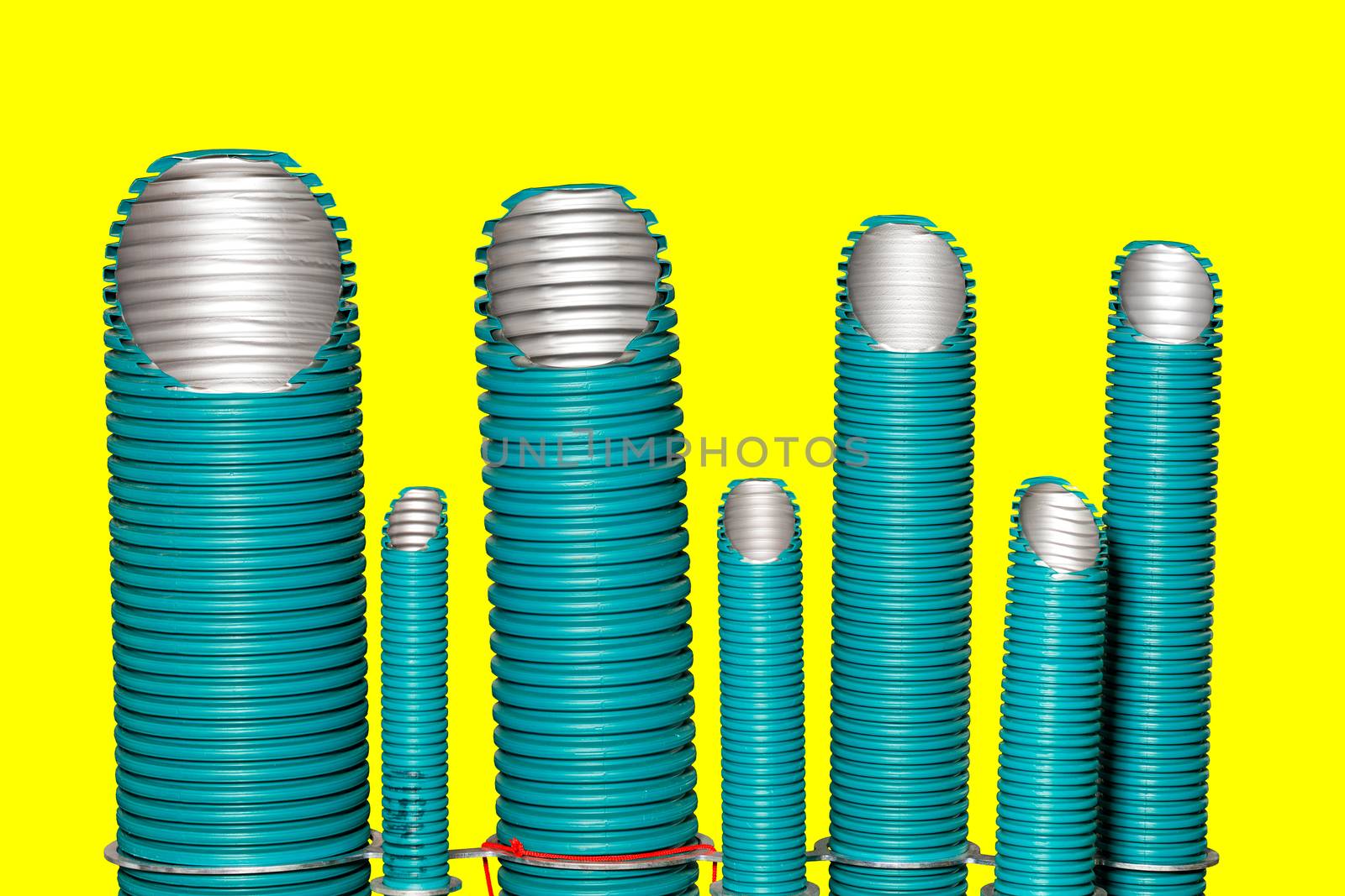 Polypropylene pipes of different diameters for use in water supply and air conditioning enterprises. The image is isolated on a yellow background.