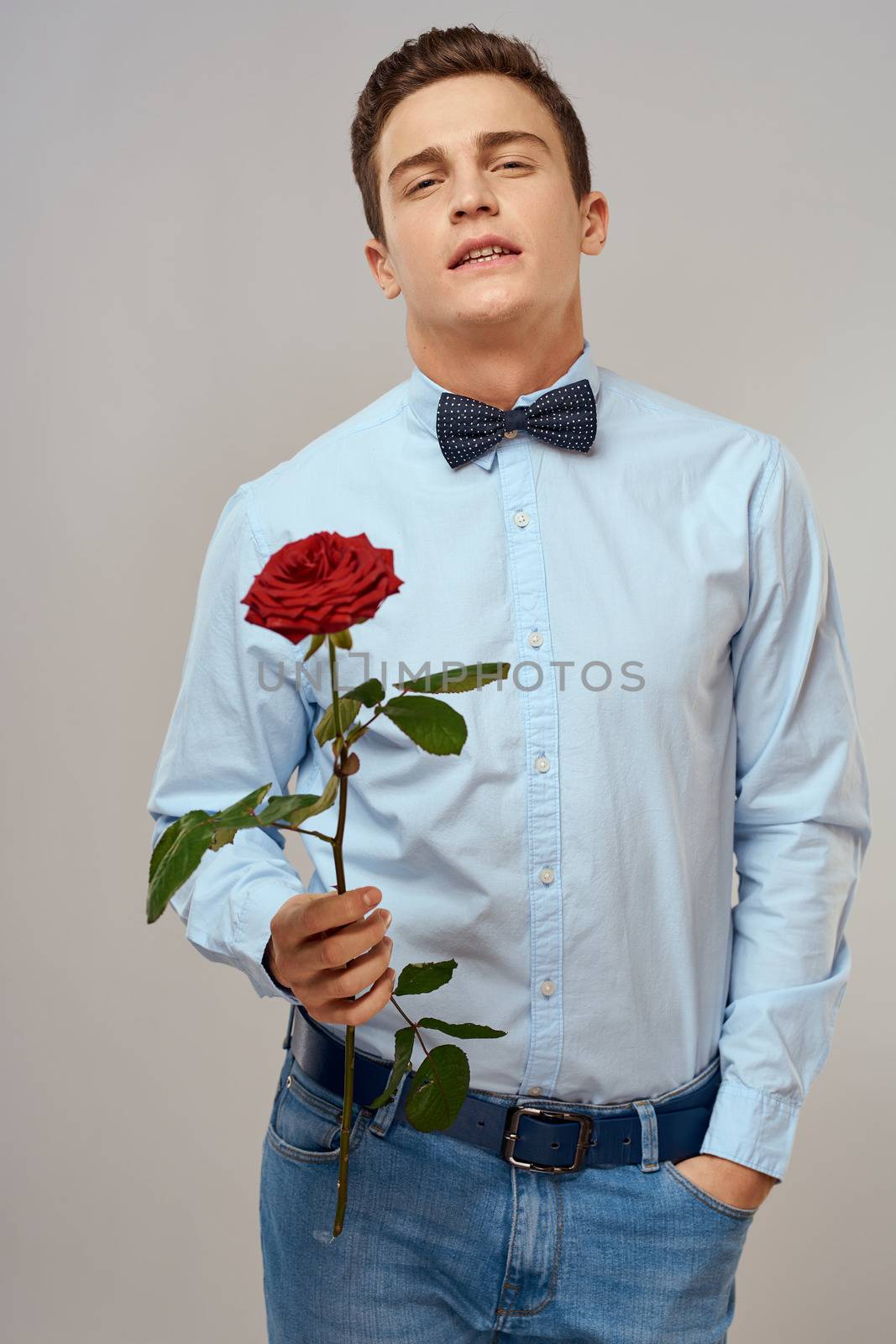 romantic man with red rose and light shirt pants suit. High quality photo