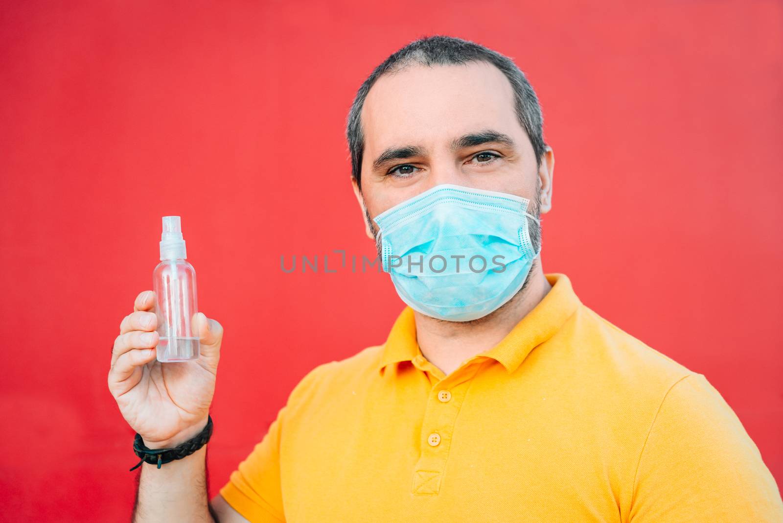 man showing bottle of antiseptic in red background.