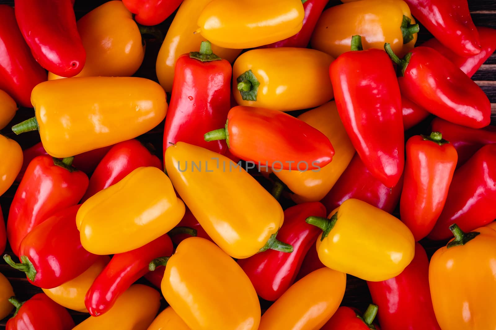 Fresh colored bell peppers on a rustic wooden background. by Fischeron