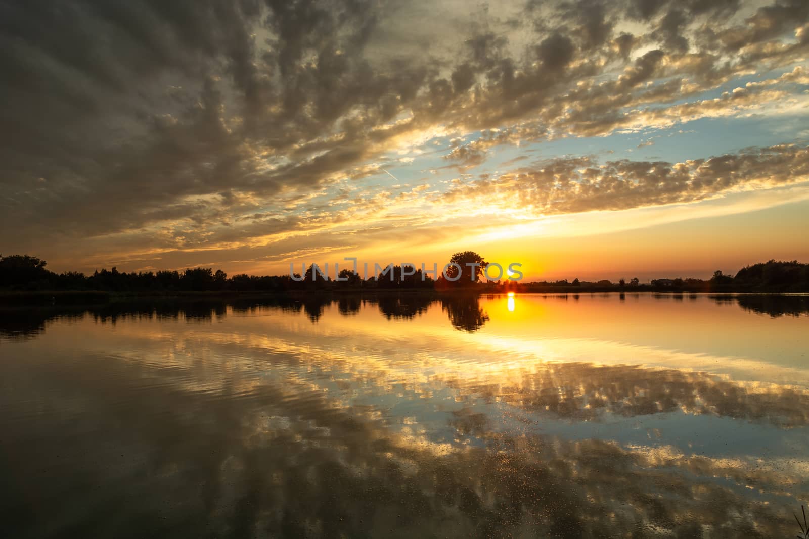 Sunset and reflection of clouds in water, evening landscape