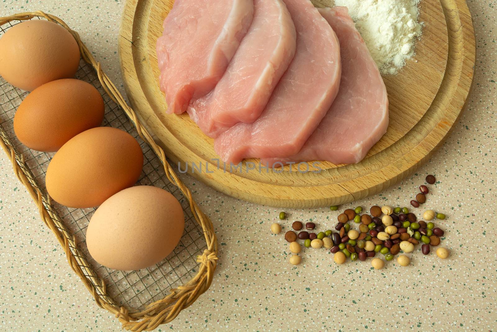 Pork loin on a wooden board, flour, eggs and spices