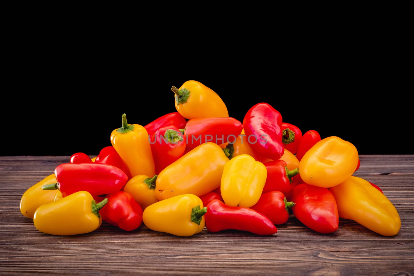 Fresh colored bell peppers on a rustic wooden background. by Fischeron