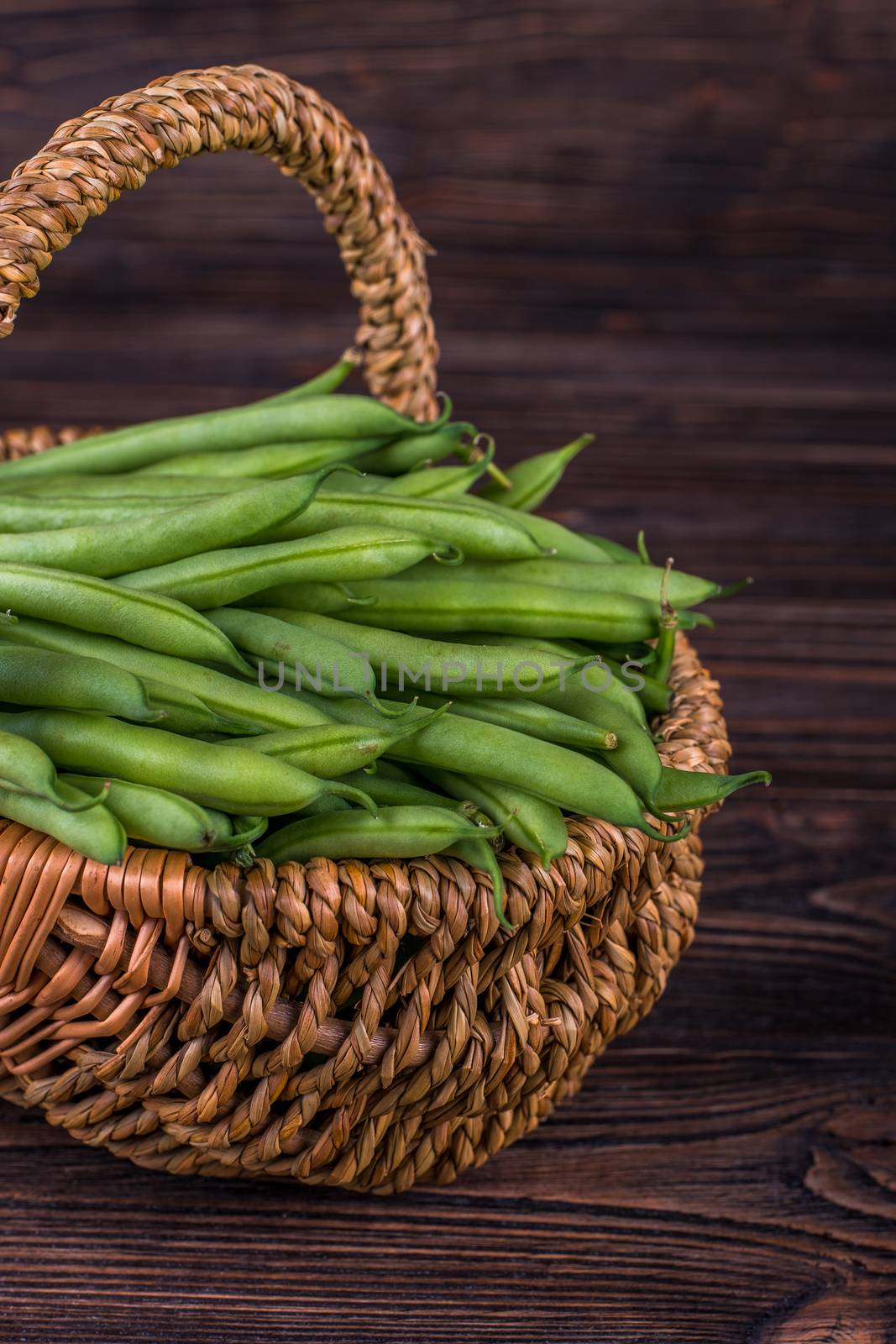 Fresh green beans on wooden table on rustic wooden background. by Fischeron