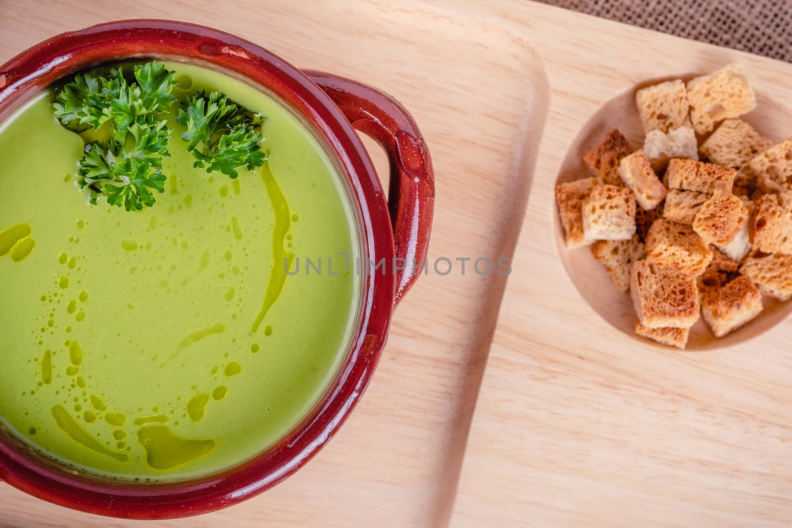 Fresh asparagus creamy soup and ingredients on a wooden table. by Fischeron