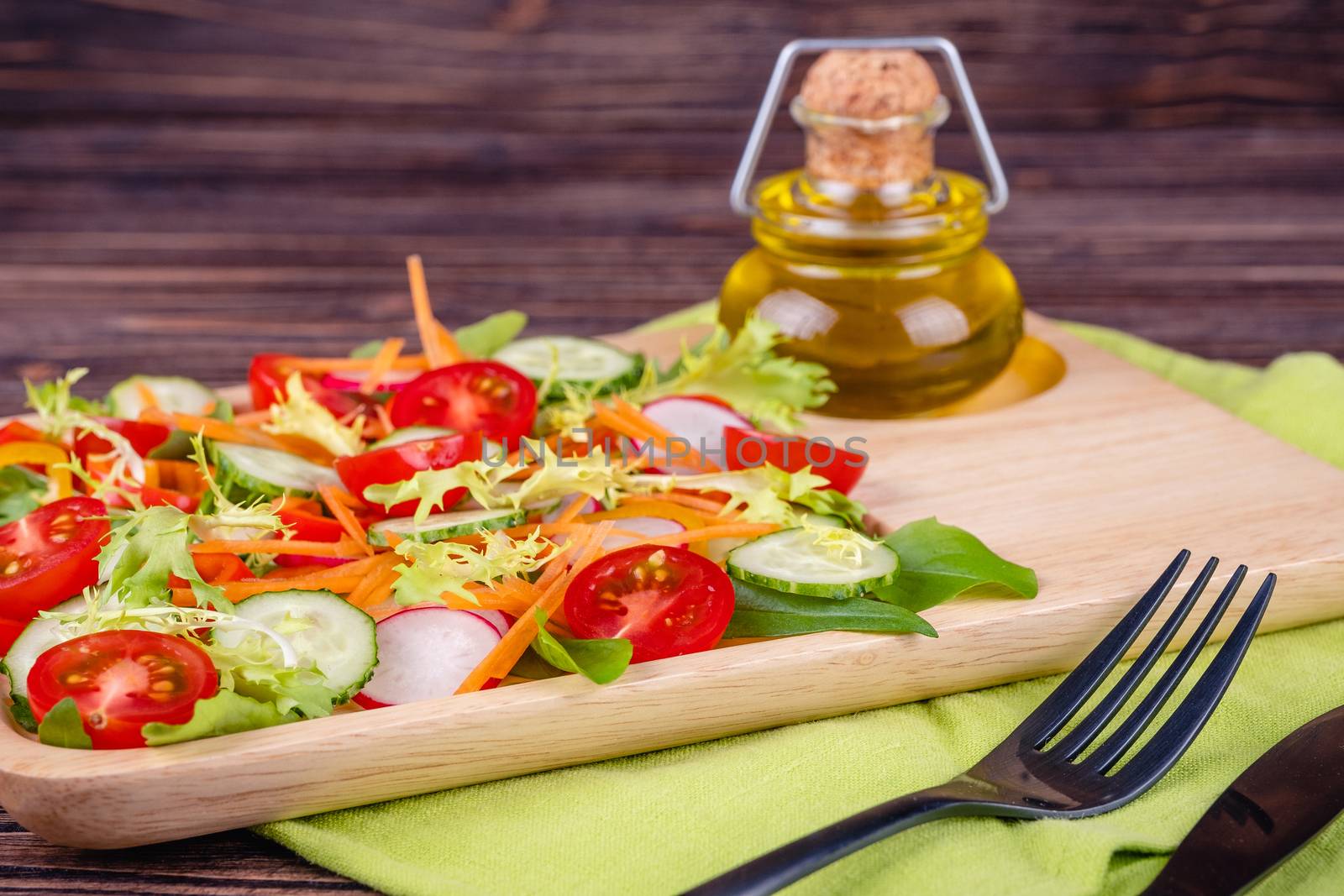 Fresh chopped vegetables on a plate on a wooden table on a rustic wooden background, selective focus