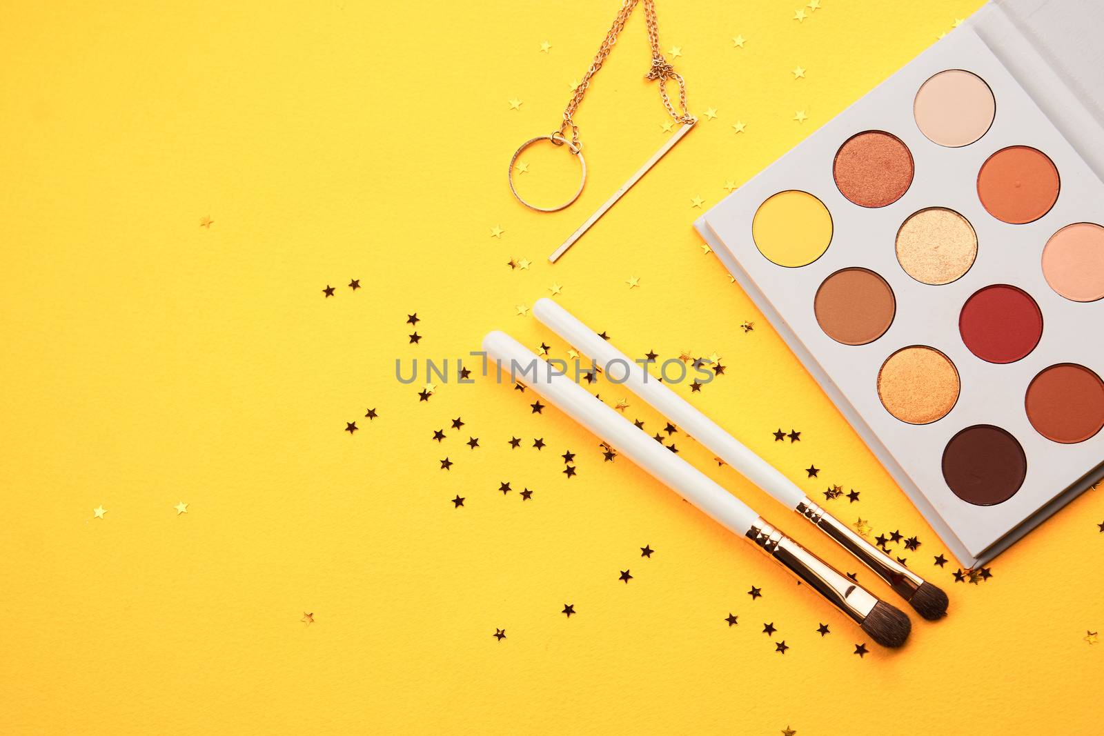 Professional eyeshadows and makeup brushes on a yellow background make-up decoration by SHOTPRIME